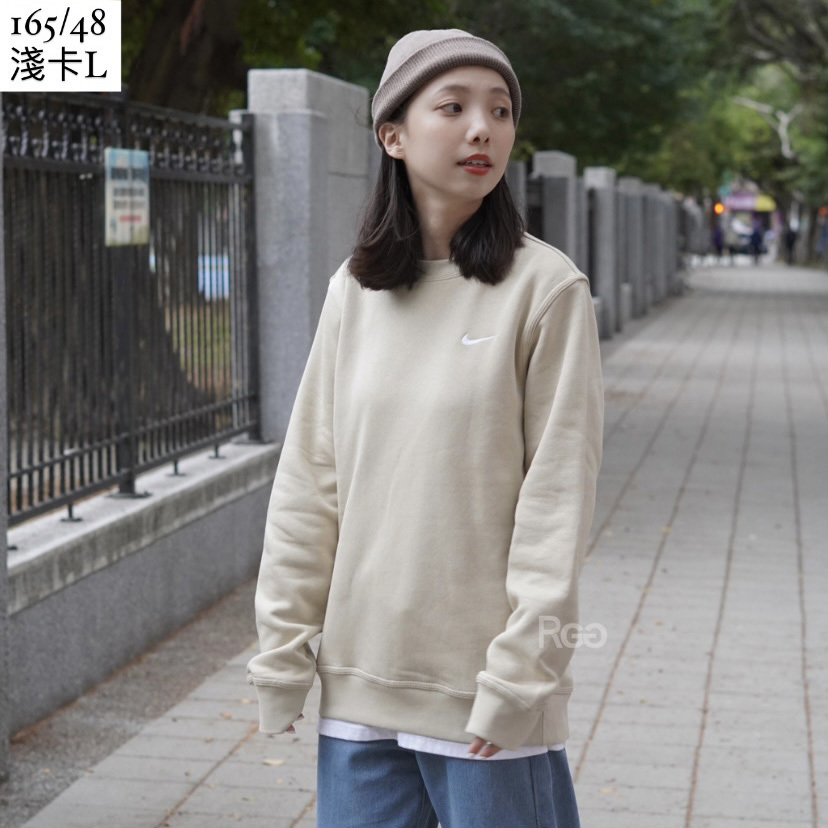 女模穿著Nike Club Fleece 單勾內刷毛大學T淺卡其半身照