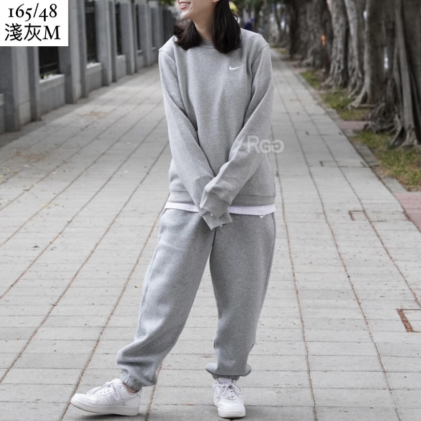 女模穿著Nike Club Fleece 單勾內刷毛大學T淺灰色全身照