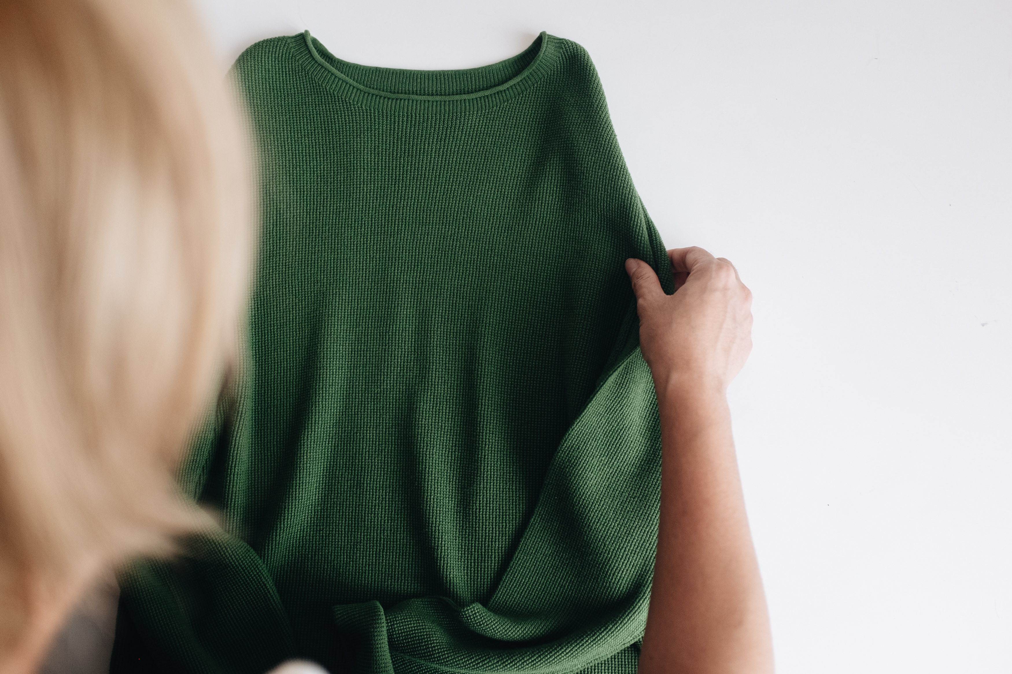 整理綠色針織上衣的設計主理人阿南