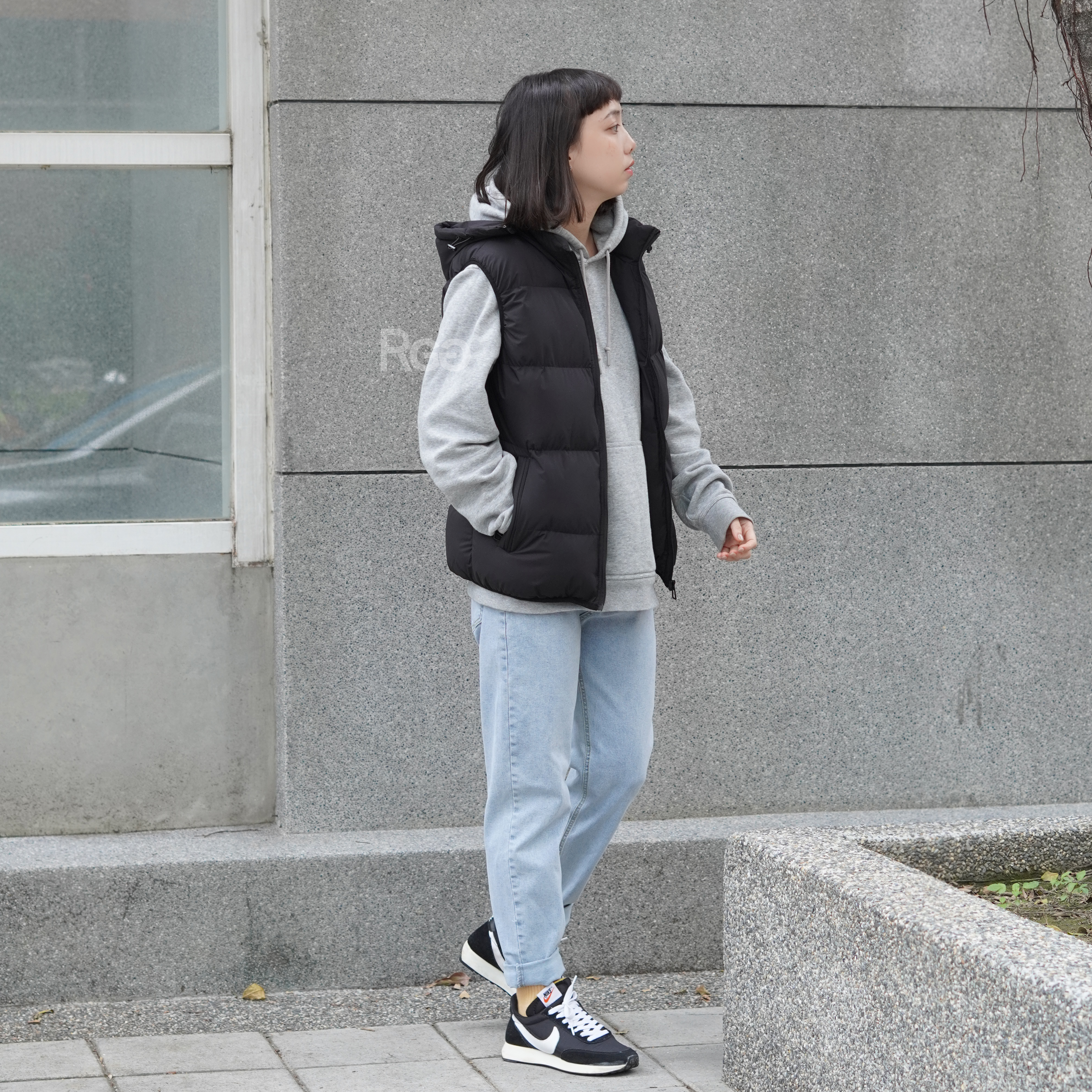 女模穿著可拆式連帽鋪棉背心黑色全身照