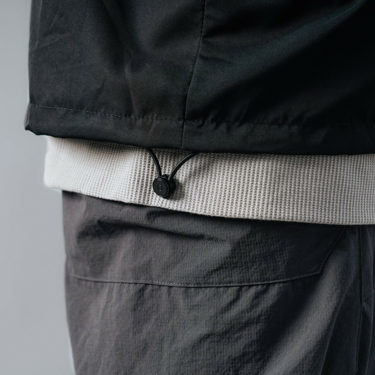 男模穿著#1031 防潑水寬鬆教練外套黑色下擺抽繩細節照