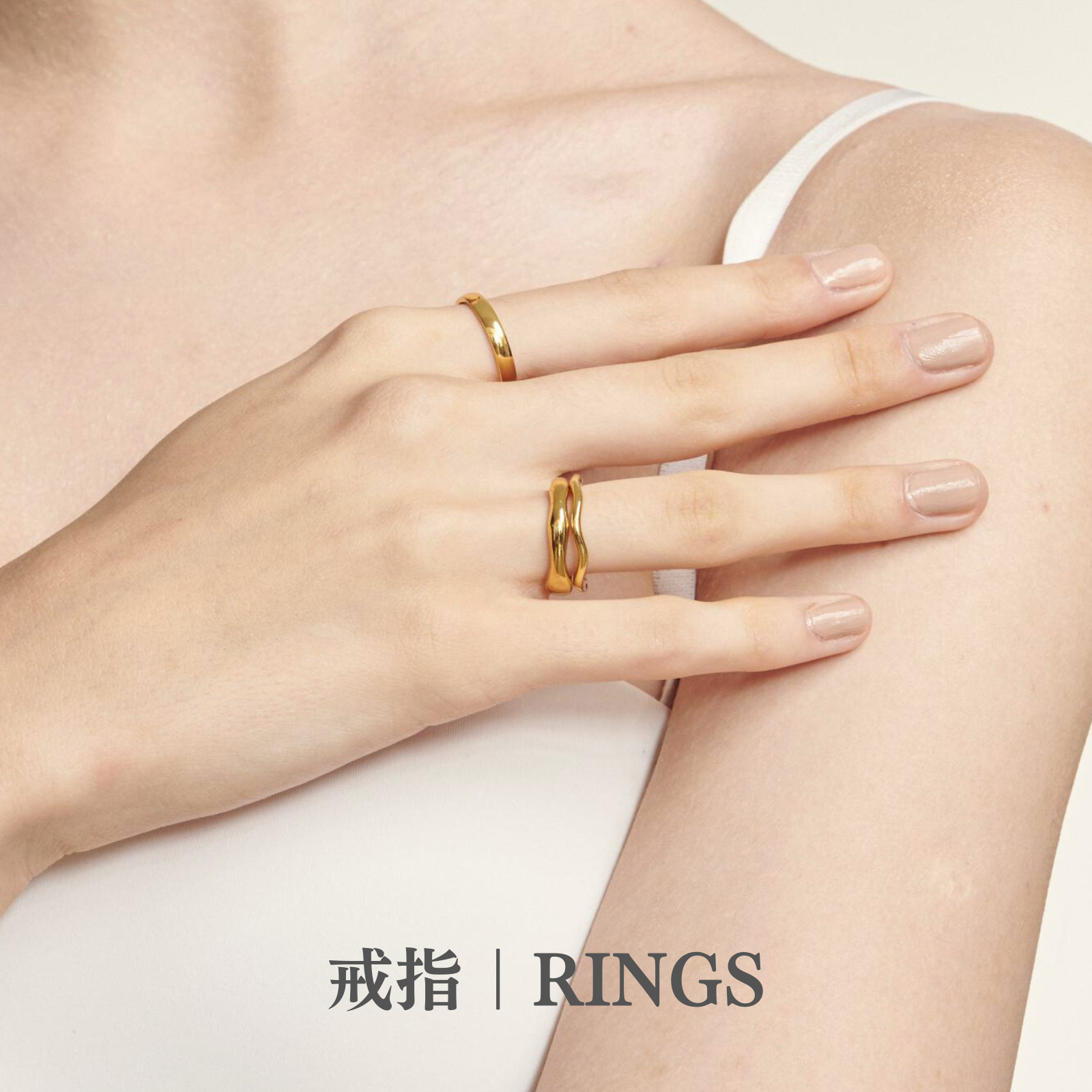 穿著白色細肩帶的女人露出白皙的手指，戴著多款金色戒指