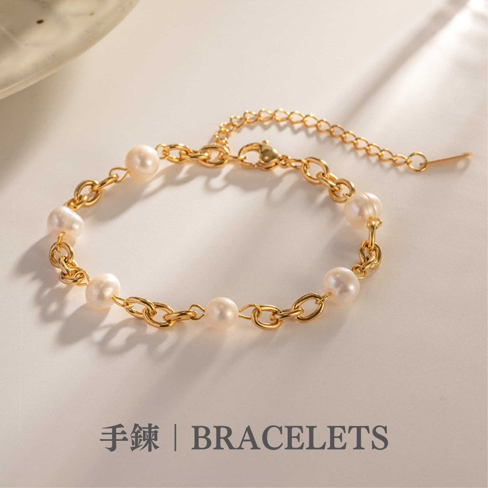 米白色的桌子上有一條淡水白色珍珠的金色手鍊