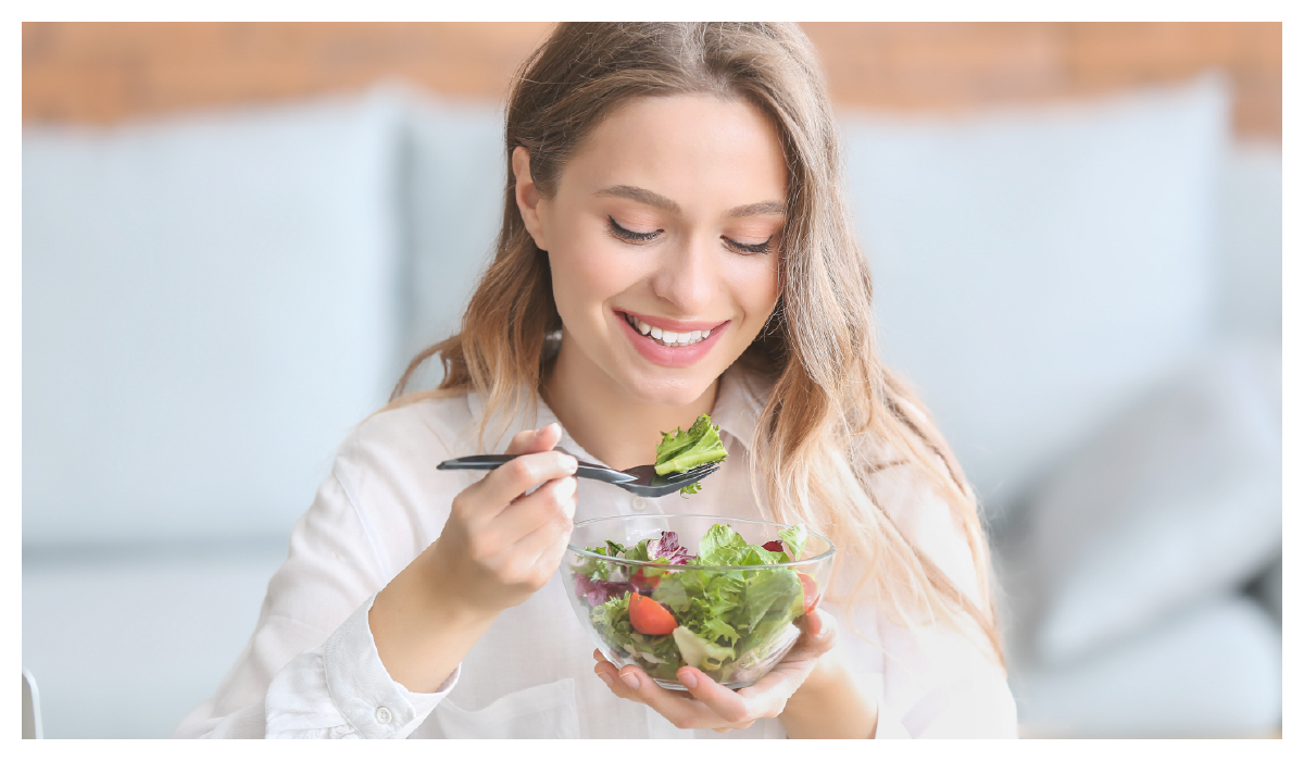 一個女生在吃生菜沙拉
