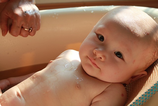 一個嬰兒正在澡盆裡洗澡。