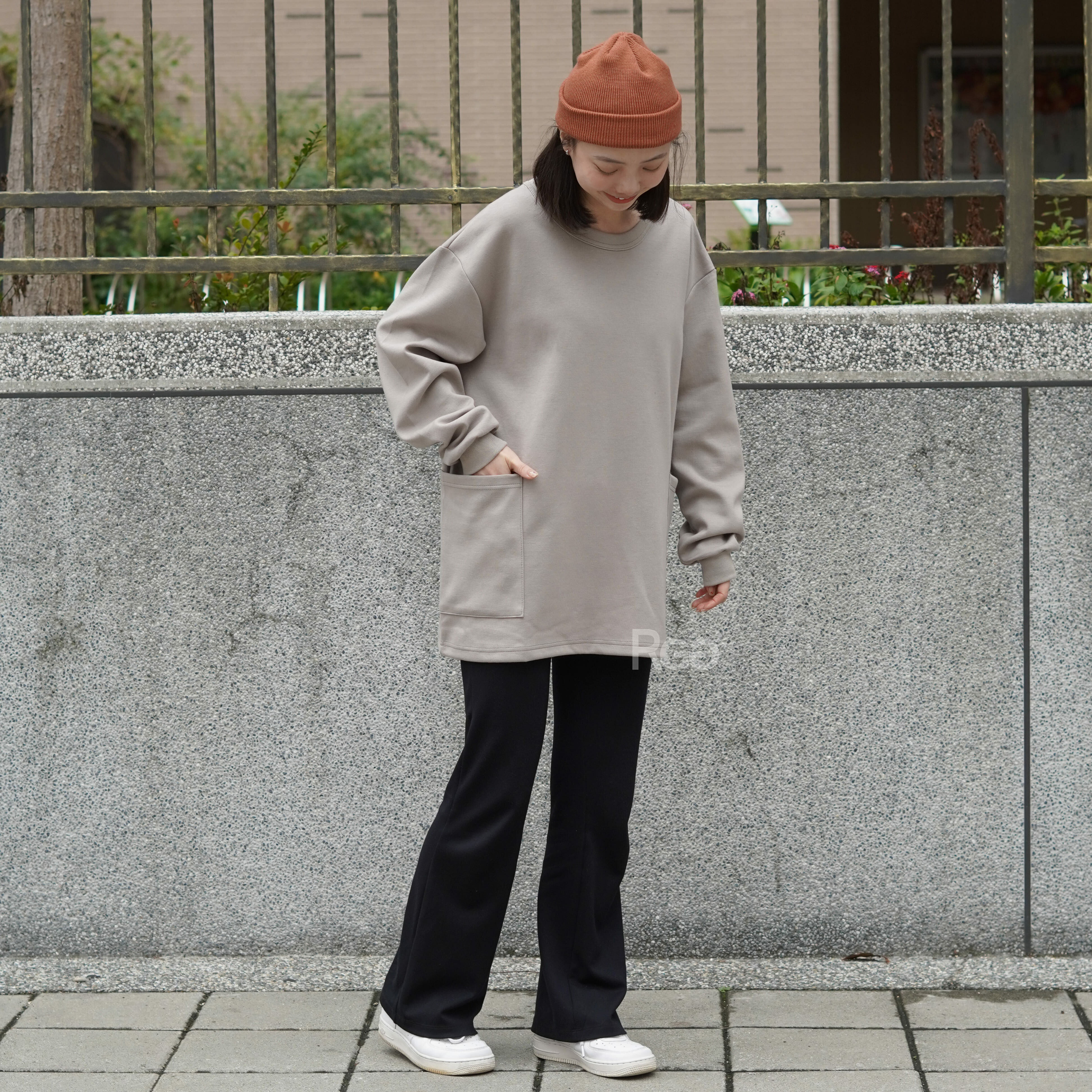 女模著台灣製太空棉落肩側雙口袋長T沙色Ｍ實著