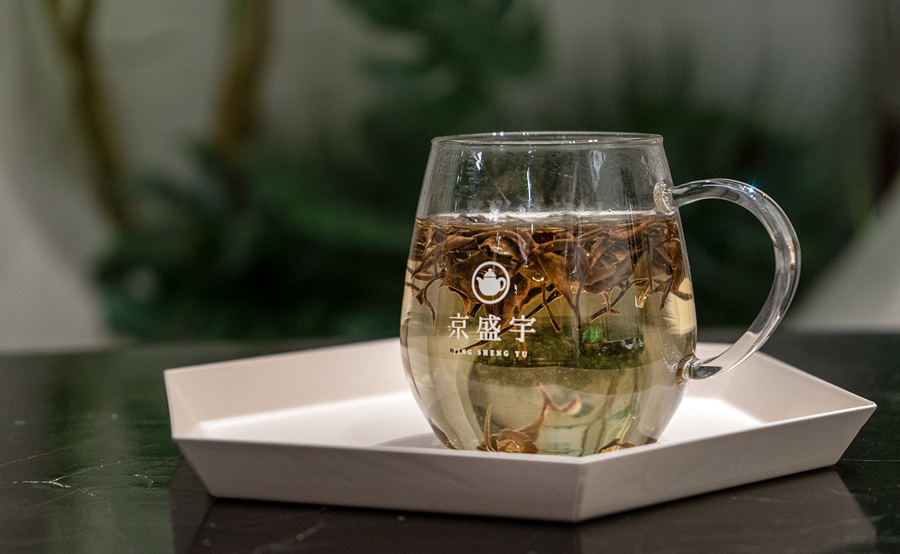 京盛宇玻璃馬克杯中裝著白茶並注入熱水