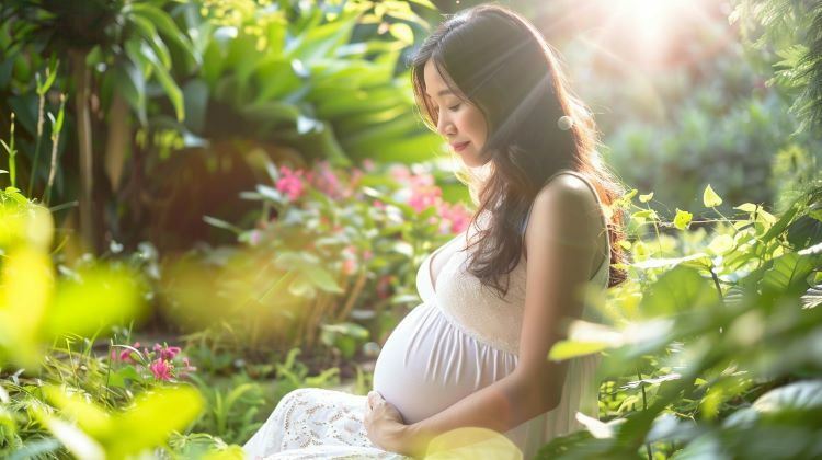 懷孕後期的女人坐在花園裡陽光下。