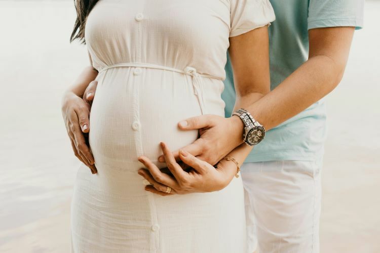支持孕婦的伴侶，兩人都深情地關注孕婦肚子裡的嬰兒。