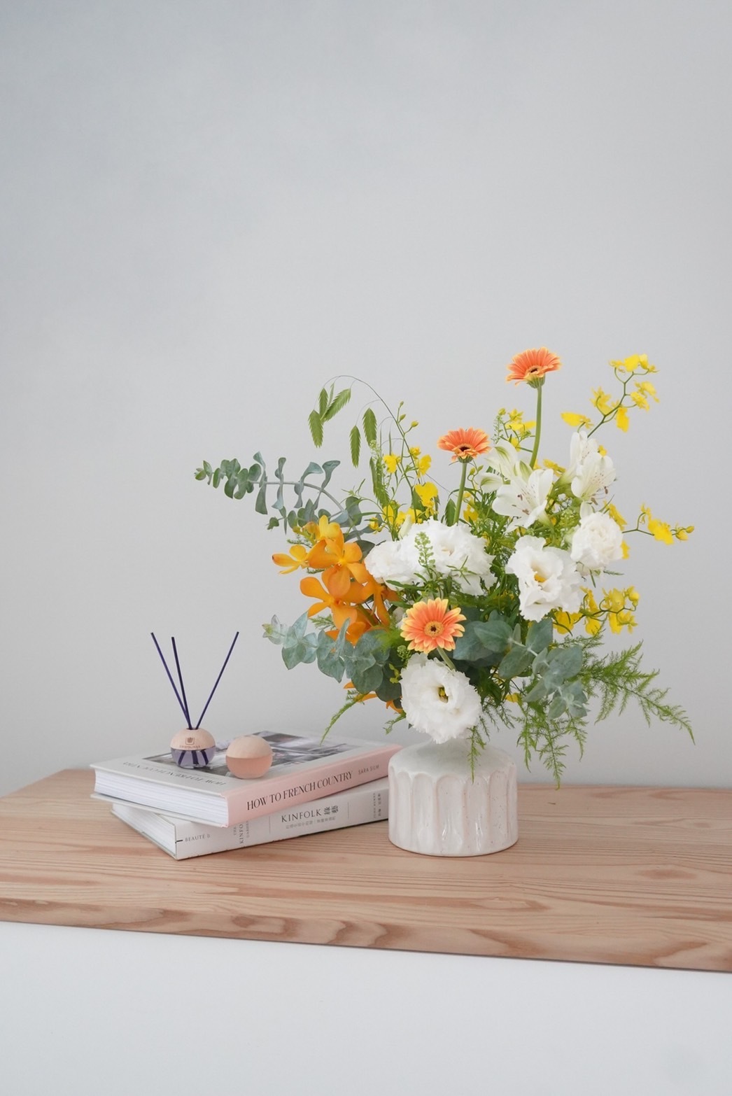 橘色小太陽、白桔梗、黃色文心蘭、小判草和尤加利，明亮動人