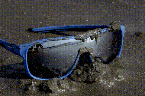 沾滿泥沙的運動太陽眼鏡在海中翻滾