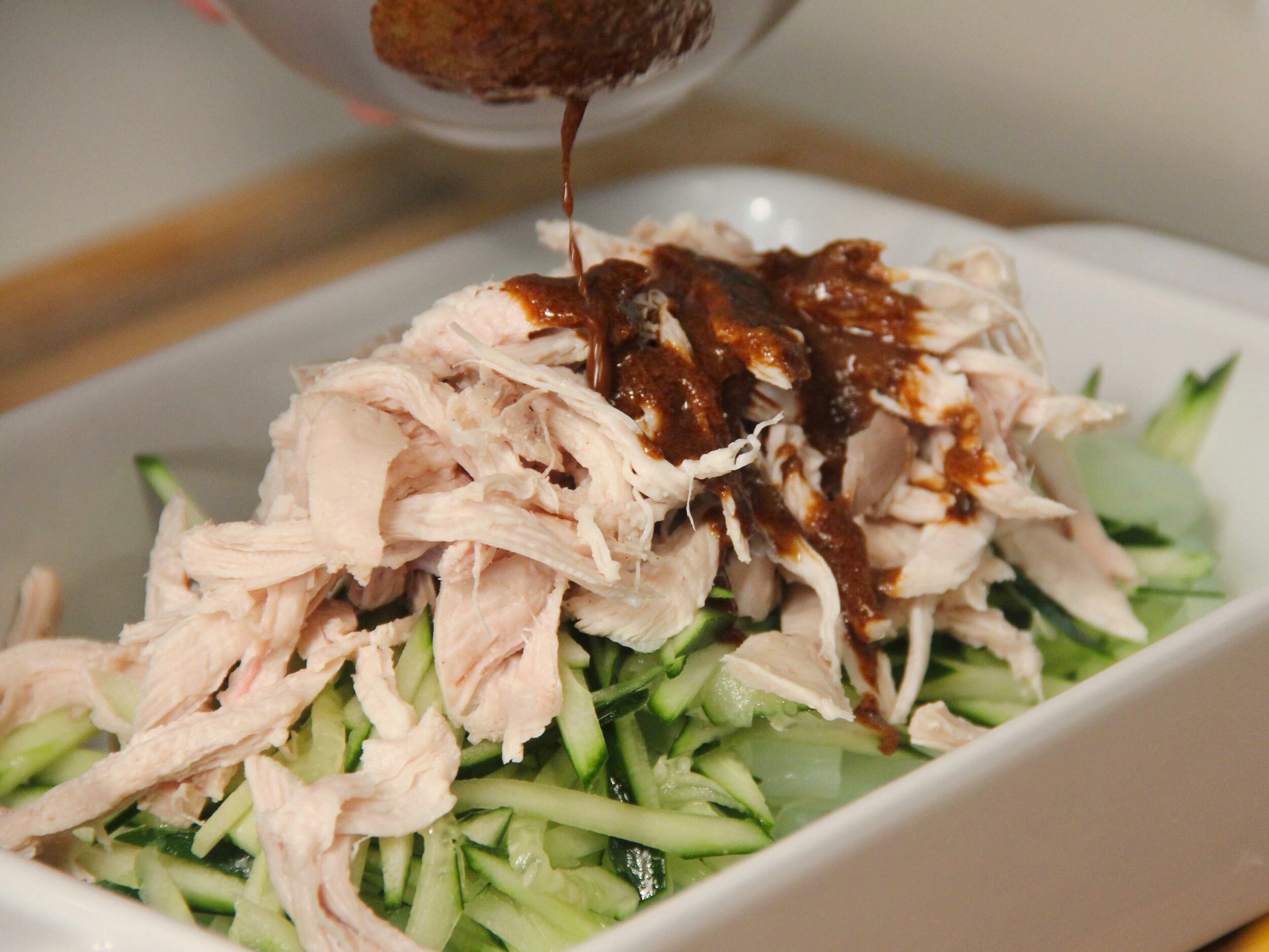 小黃瓜切絲，粉皮切段和雞絲裝盤，再淋上芝麻醬