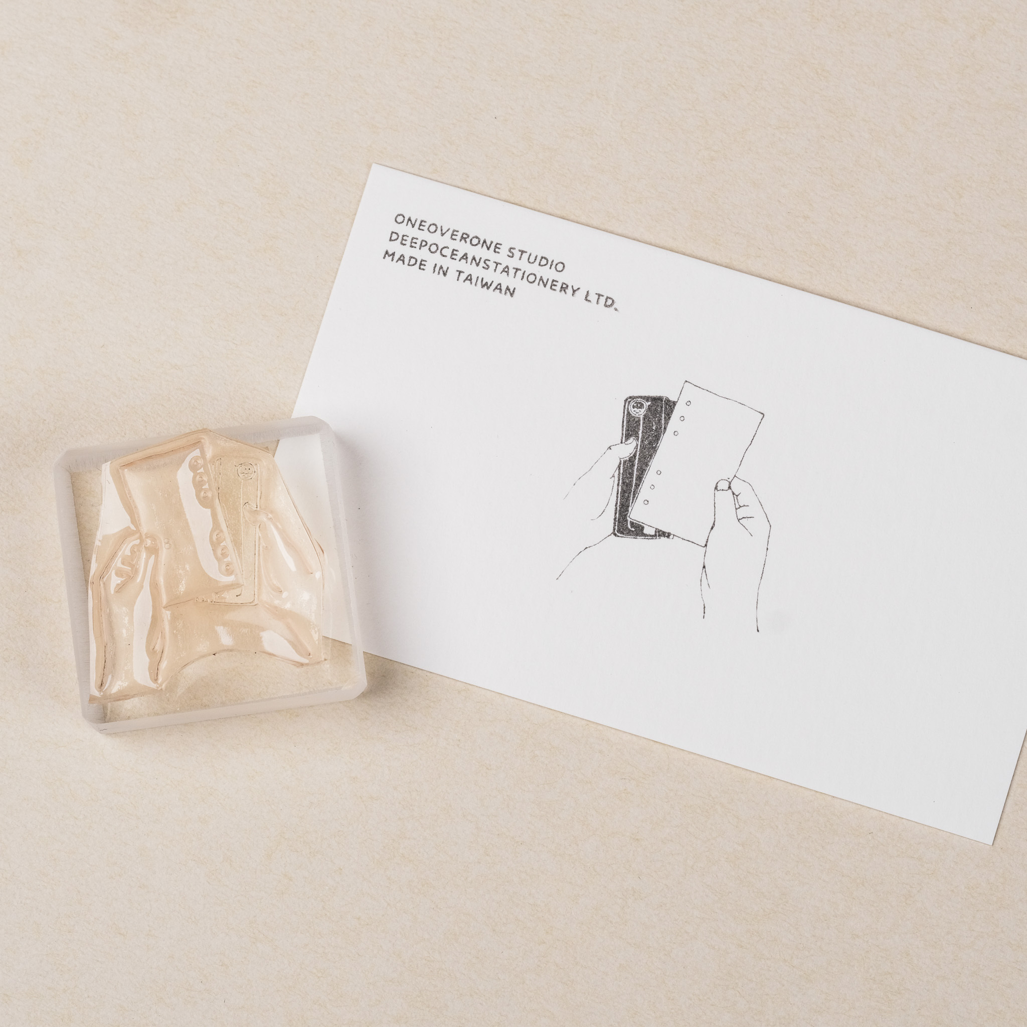 拿著內頁與打孔機的手 膠版印章｜一分之一工作室 台灣