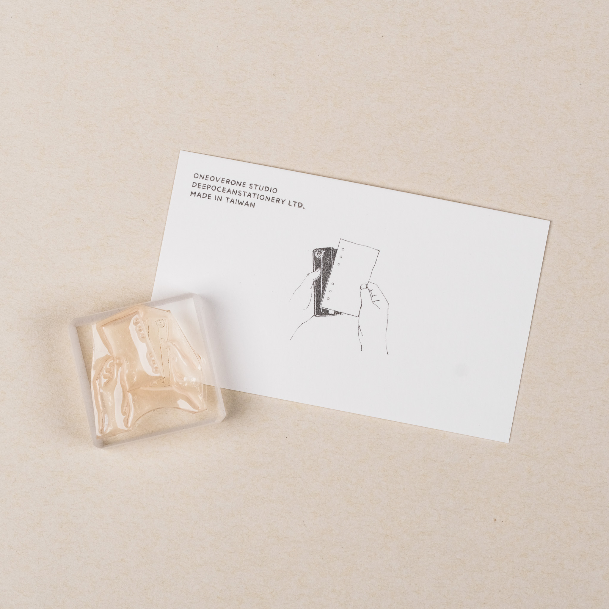 拿著內頁與打孔機的手 膠版印章｜一分之一工作室 台灣