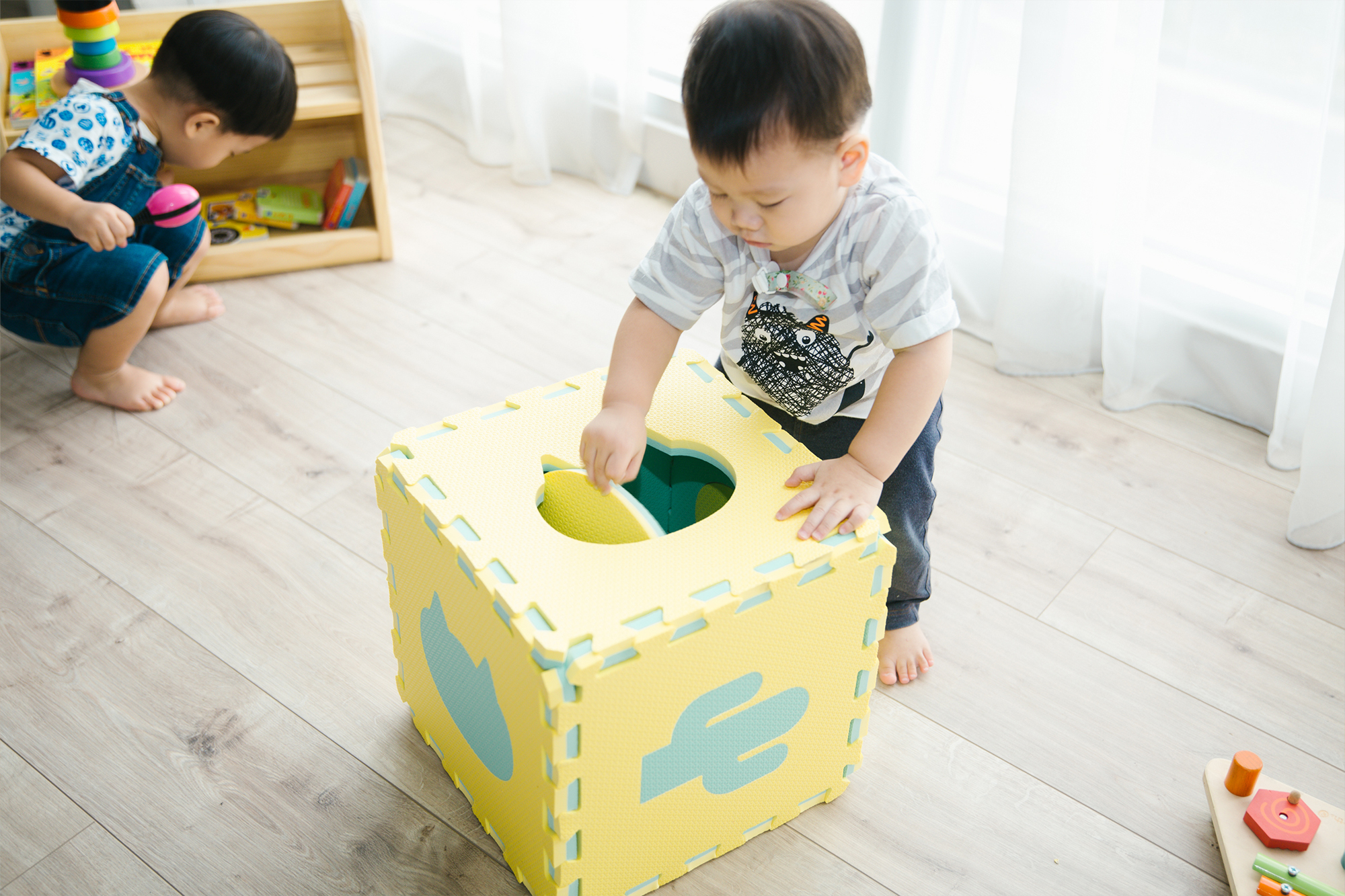 這是一張把遊戲地墊拚成立體的盒子，寶寶正在玩的照片