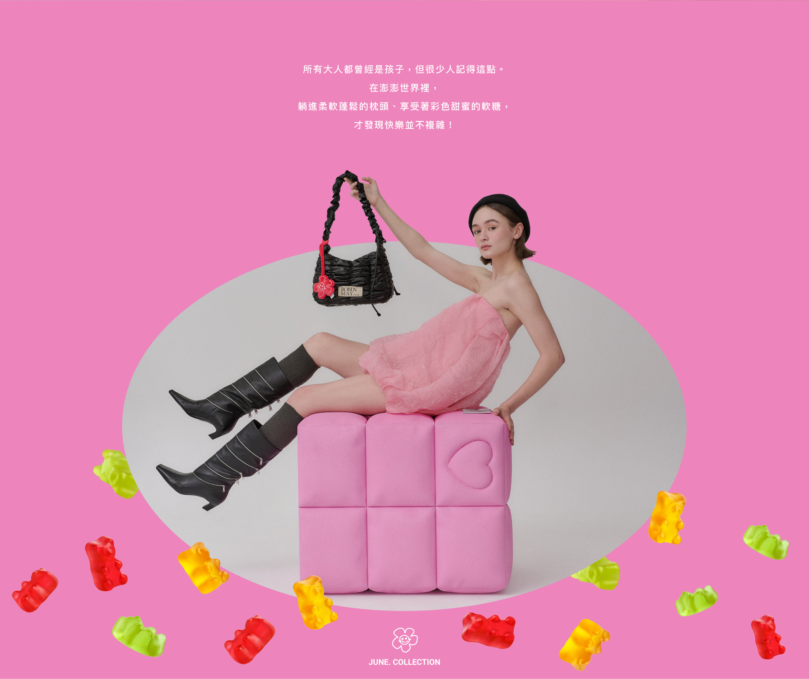 短髪女生穿著粉紅色抹胸澎鬆洋裝，坐在粉色的柱子上，手拿黑色的Meego 雲朵包包。