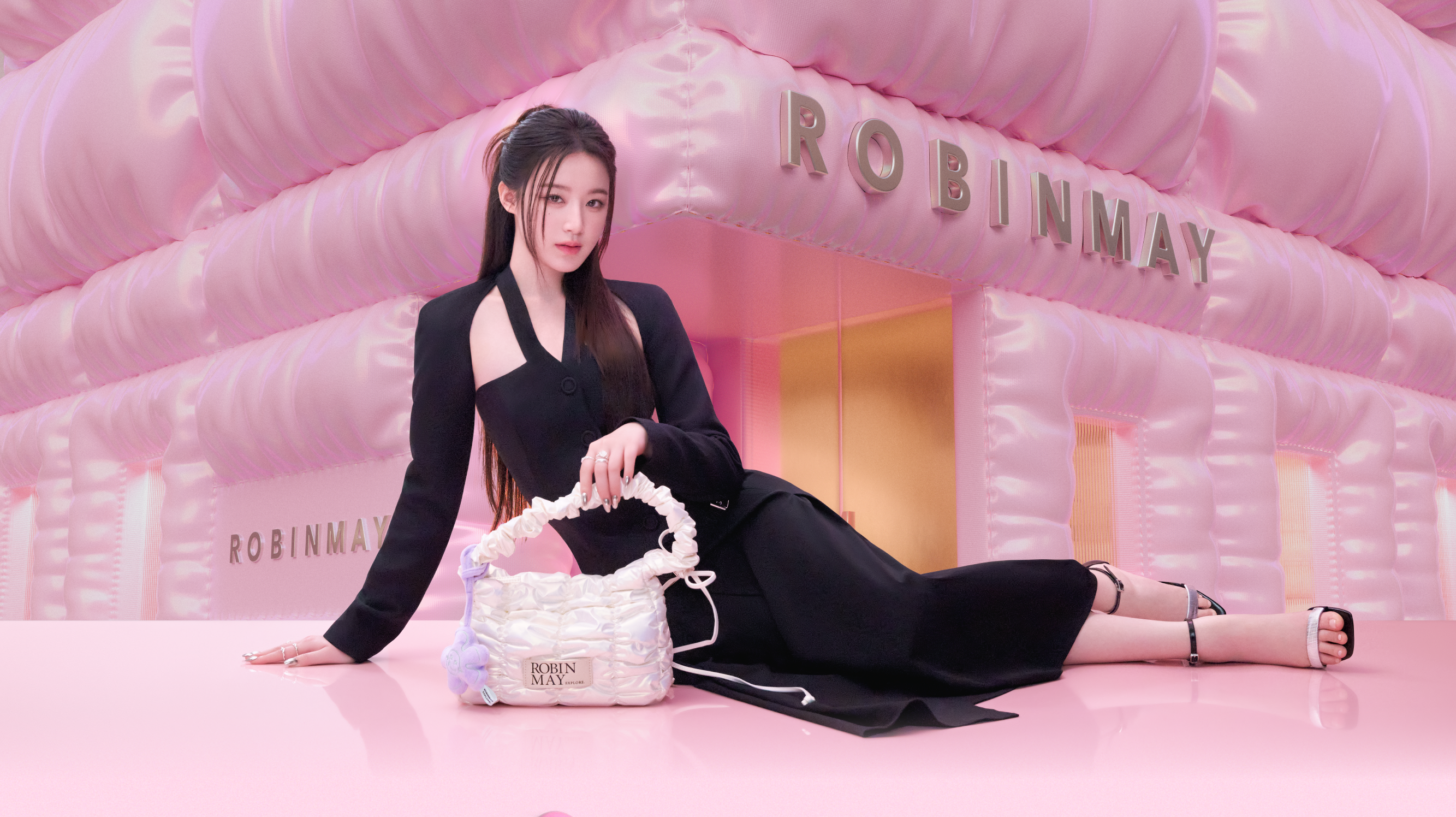 舒華代言ROBINMAY系列包款。舒華身穿黑色緊身洋裝，以側臥姿態展示ROBINMAY 舒華系列 白色的Meego 肩背包。