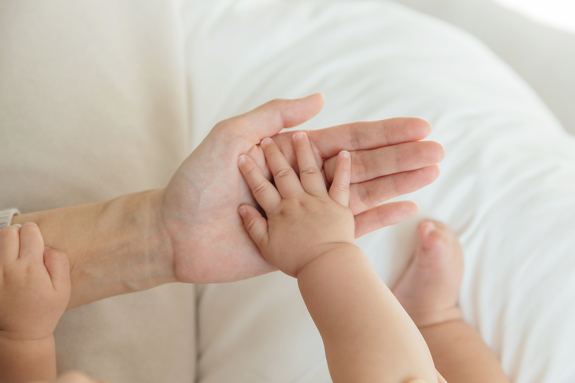 這是一張寶寶的手放在大人手上的照片