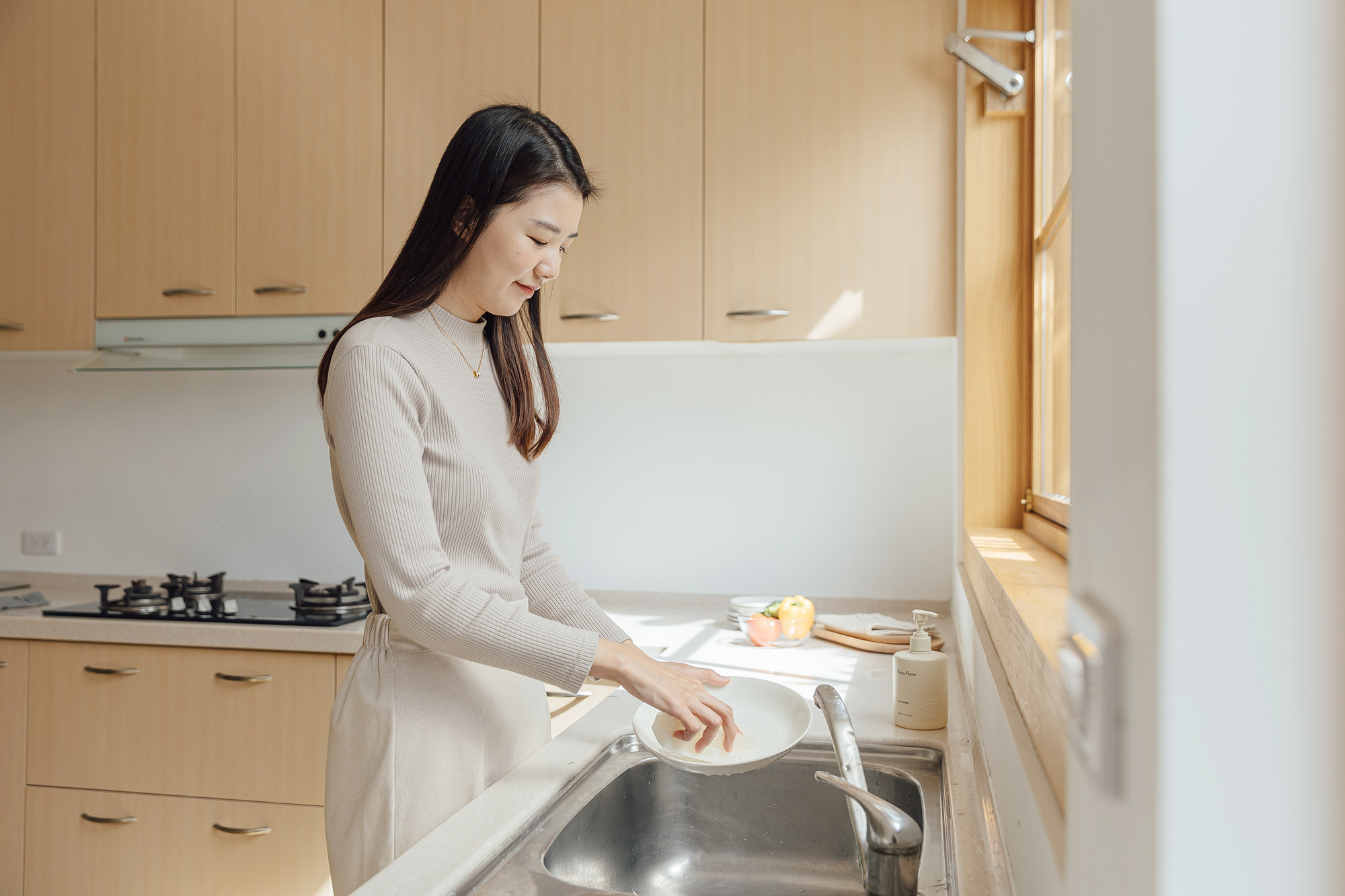這是一張一位女生正在洗碗的照片