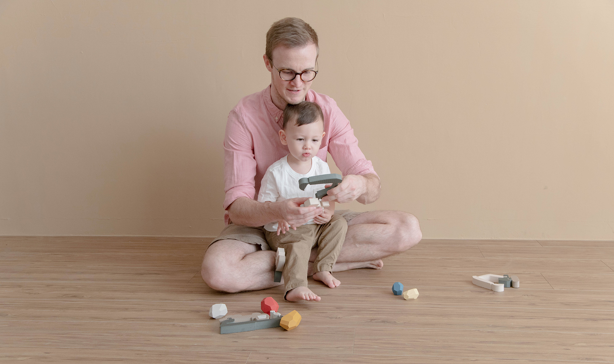 這是一張小孩跟爸爸在玩知育玩具的照片