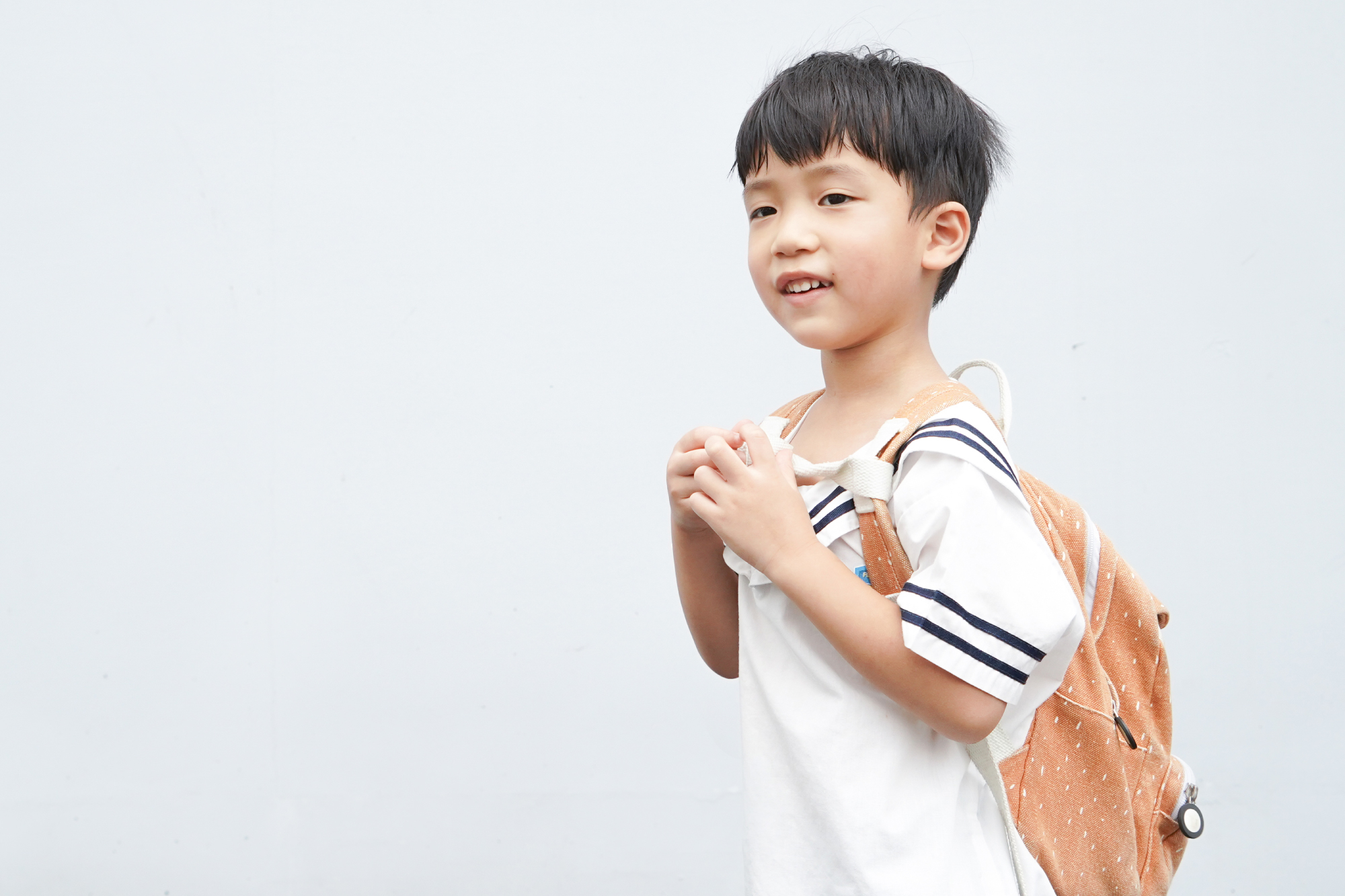 這是一張小男孩背著書包的照片