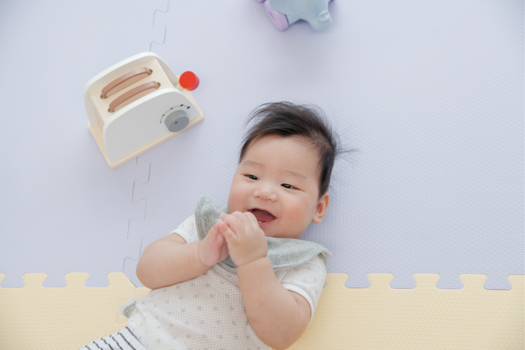 這是一張寶寶躺在地墊上的照片