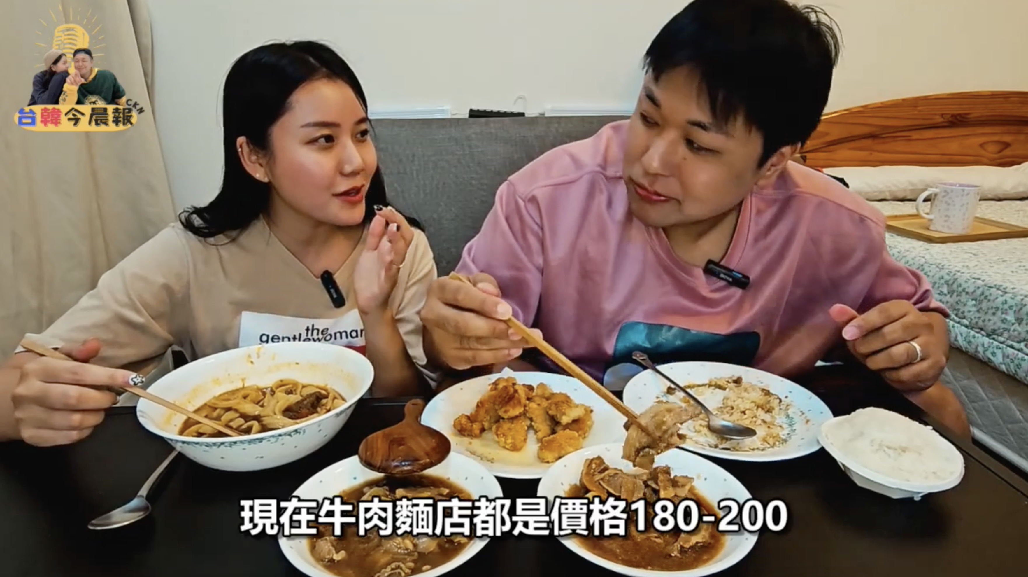 年輕男女繼續享用餐點。女性正在吃牛肉麵。桌上擺放著多種菜餚。畫面下方有字幕"現在牛肉麵店都是價格180-200"。"。