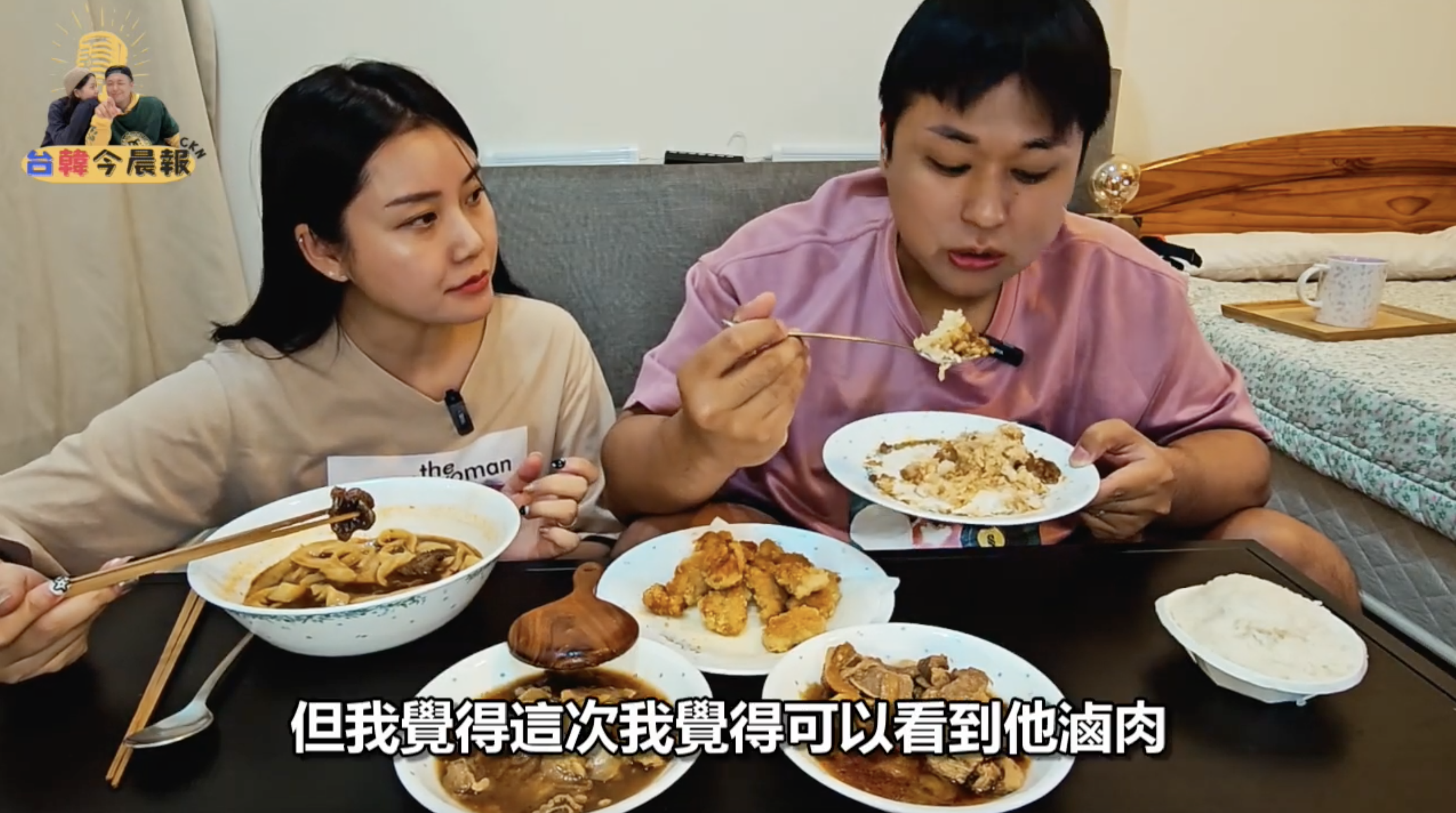 同一對年輕男女正在品嚐食物。女性正在吃湯麵，男性則在吃米飯。桌上擺放著多種菜餚。畫面下方有字幕"但我覺得這次我覺得可以看到他滷肉"。