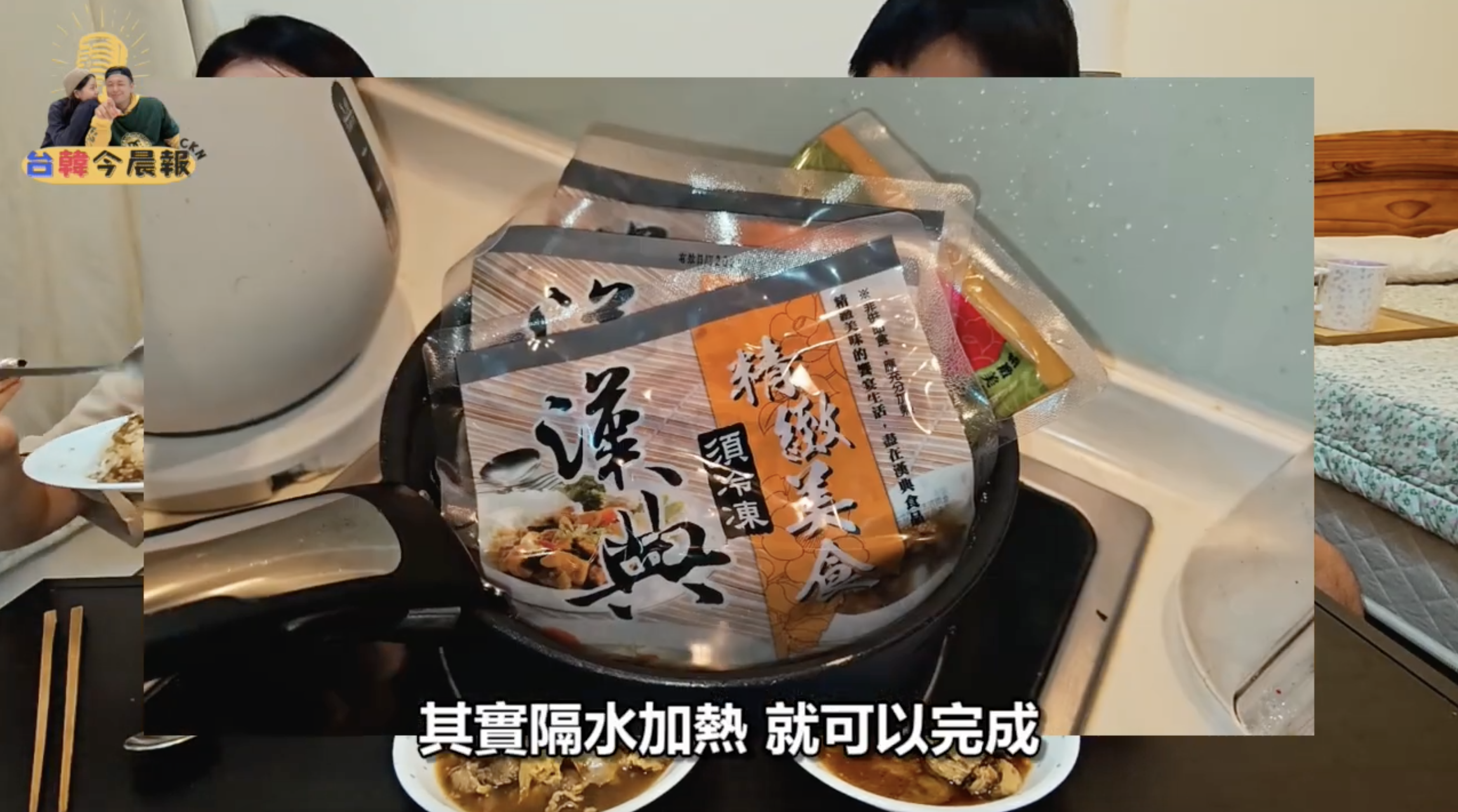 特寫鏡頭顯示一個鍋子,裡面放著幾包包裝食品。畫面下方有字幕"其實隔水加熱就可以完成"。