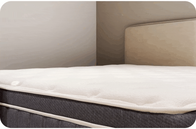 女孩將紅酒杯放在獨立筒床墊上，接著往床邊一坐，紅酒杯絲毫不動，是因為獨立筒彈簧的點式分布支撐，抗震零干擾。