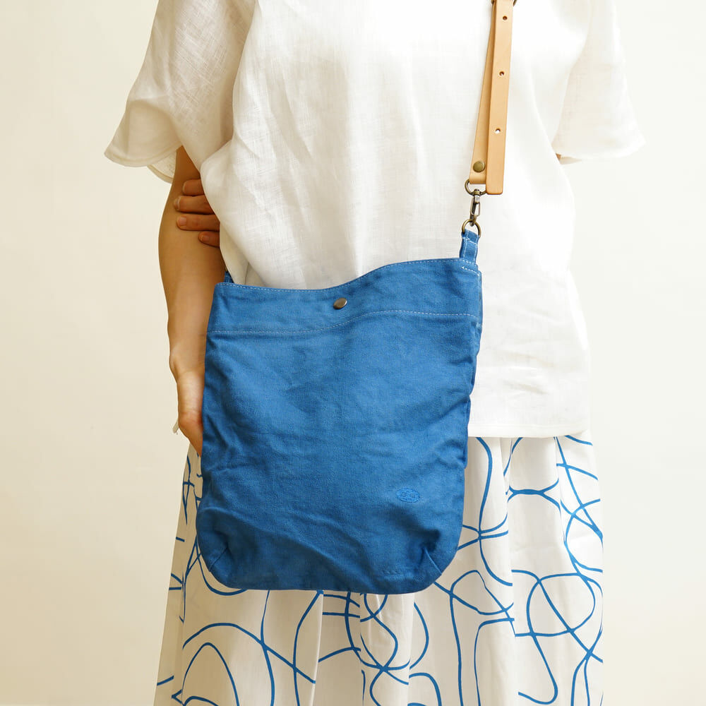 Faye 藍染時尚小背包，藍色水洗帆布搭配皮革細節，小巧輕便適合日常外出與城市通勤