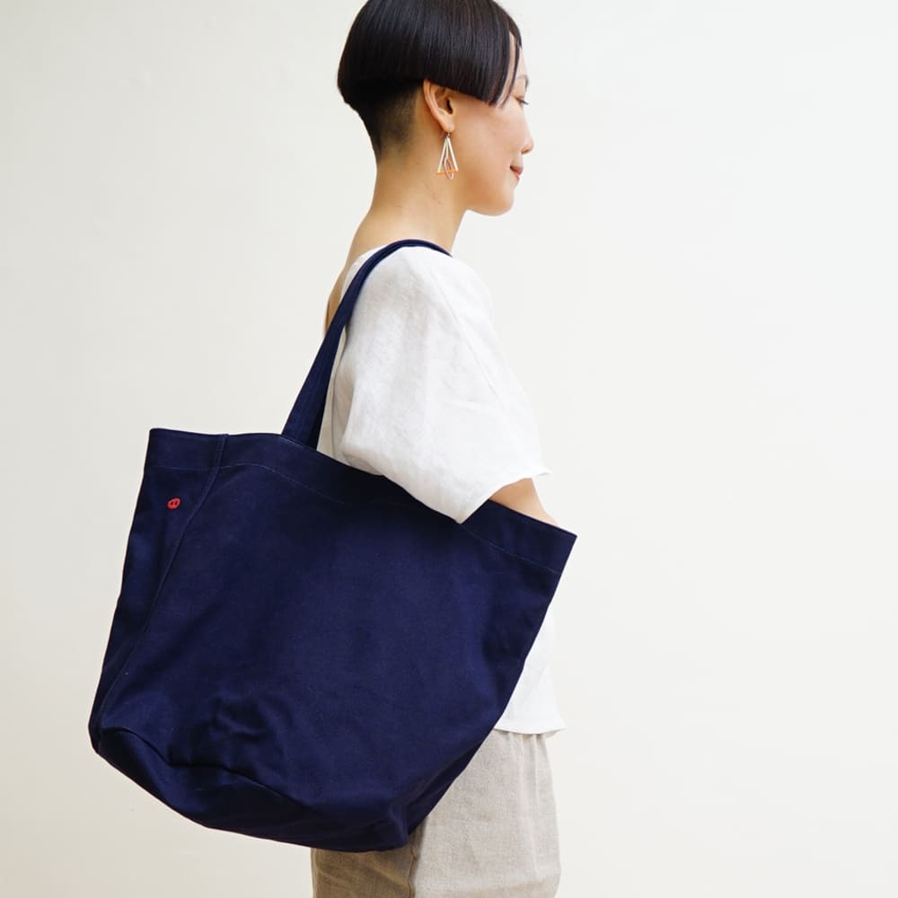 Camping Plus 深紫色圓桶形帆布托特包正面展示，簡約設計，適合日常與戶外使用