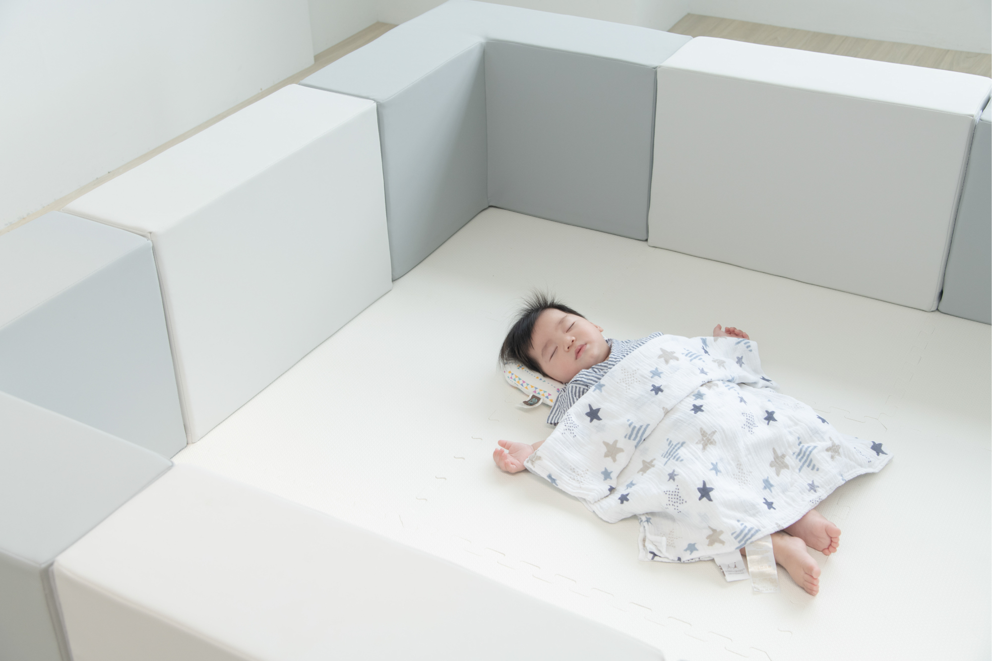 這是一張寶寶躺在圍欄裡的照片