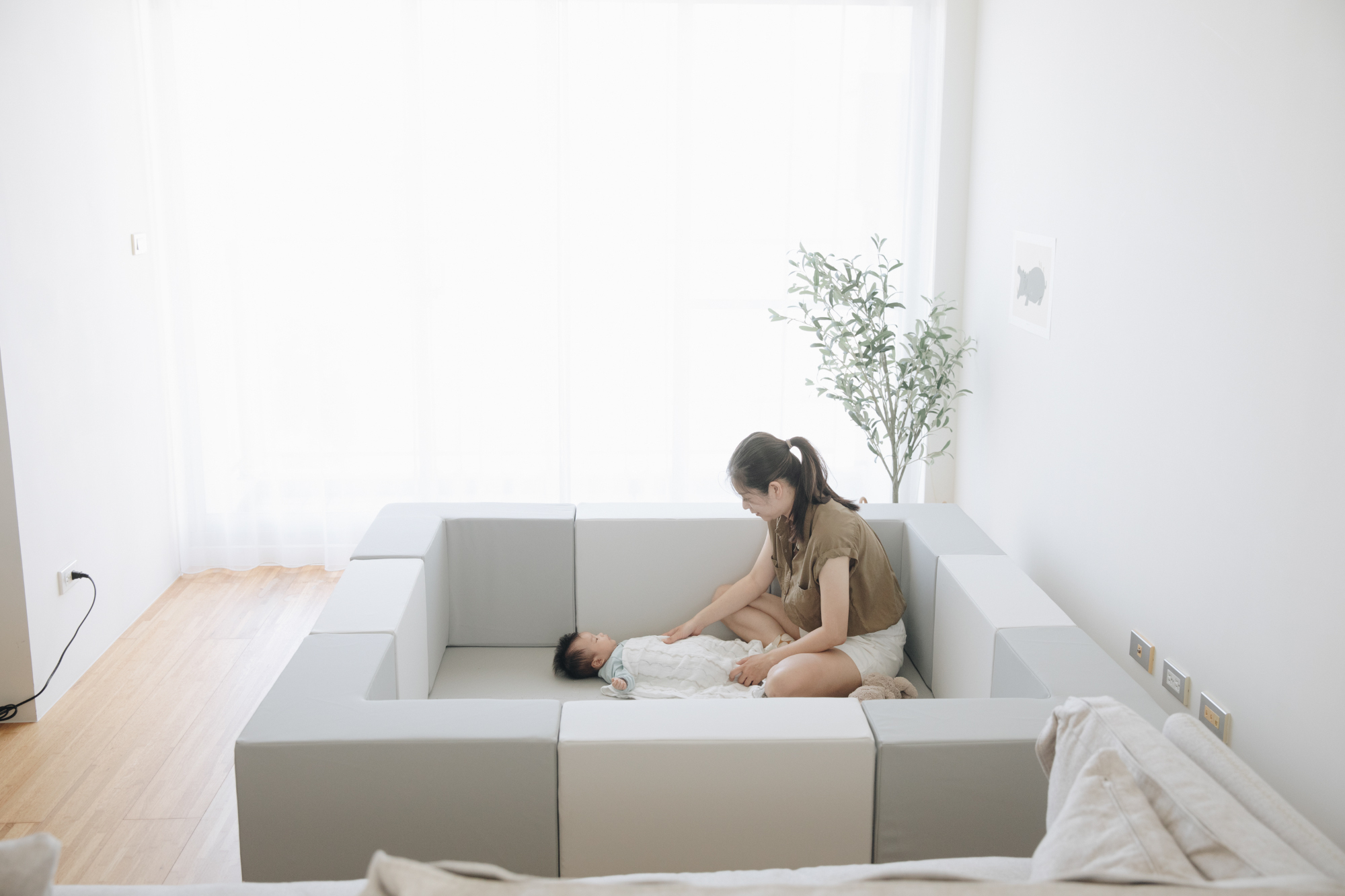 這是一張寶寶和媽媽在圍欄裡的照片