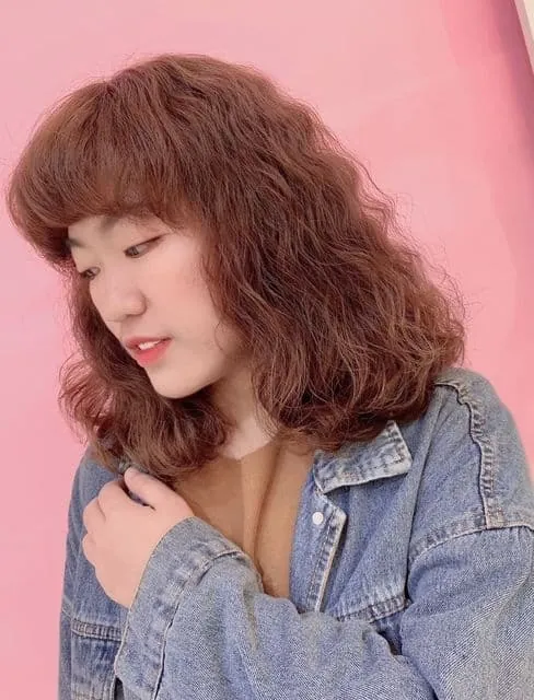 Hair length above the shoulders with small curls, giving a playful and cute look.