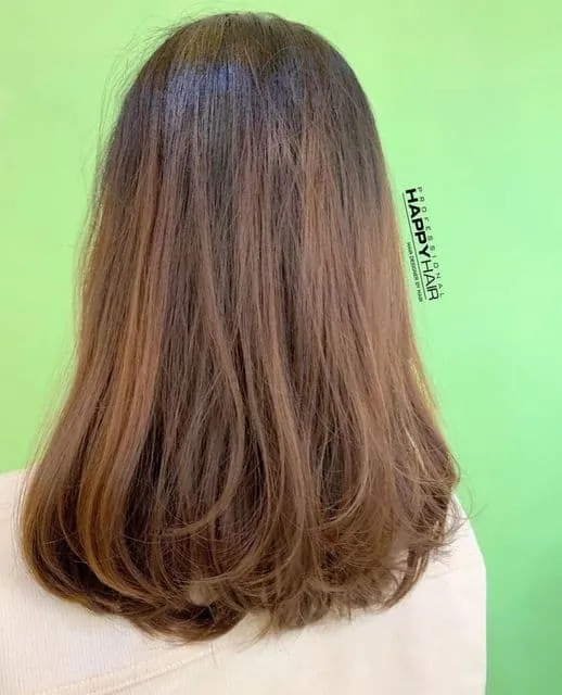 Hair length is below the shoulders, with a simple C-shaped curl at the ends.