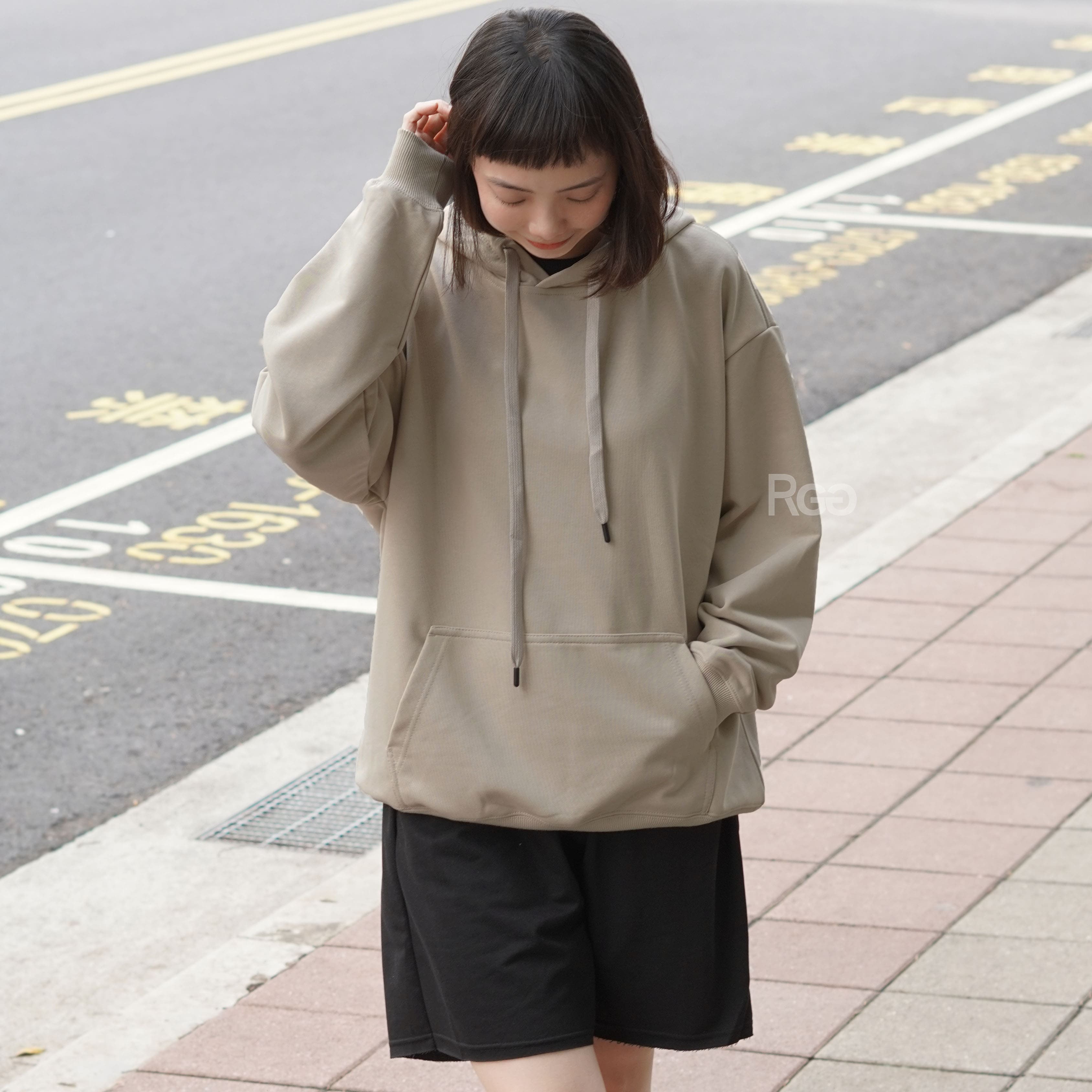 女模穿著ArriveGuide 重磅寬版落肩帽T燕麥色