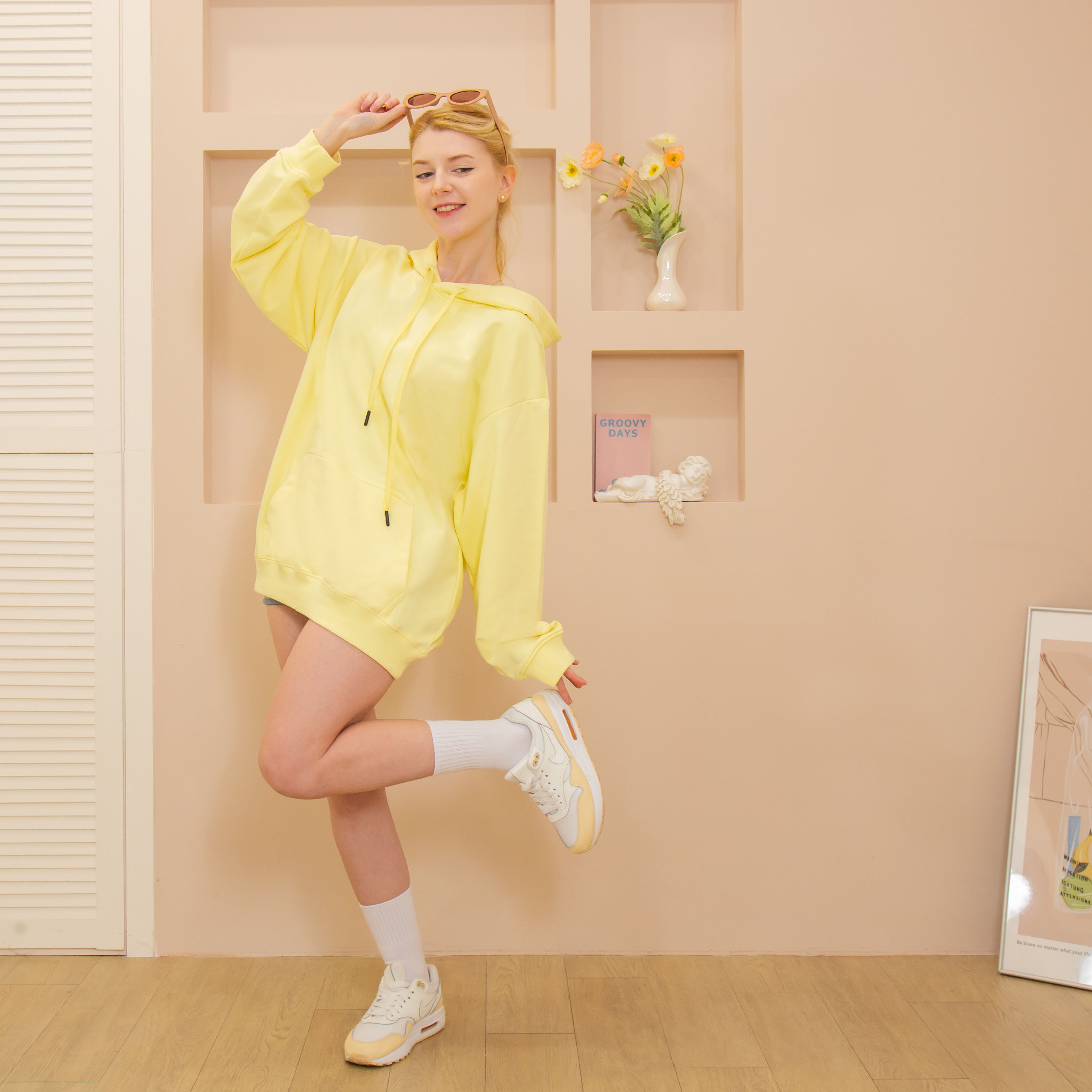 女模穿著ArriveGuide 重磅寬版落肩帽T雛菊黃