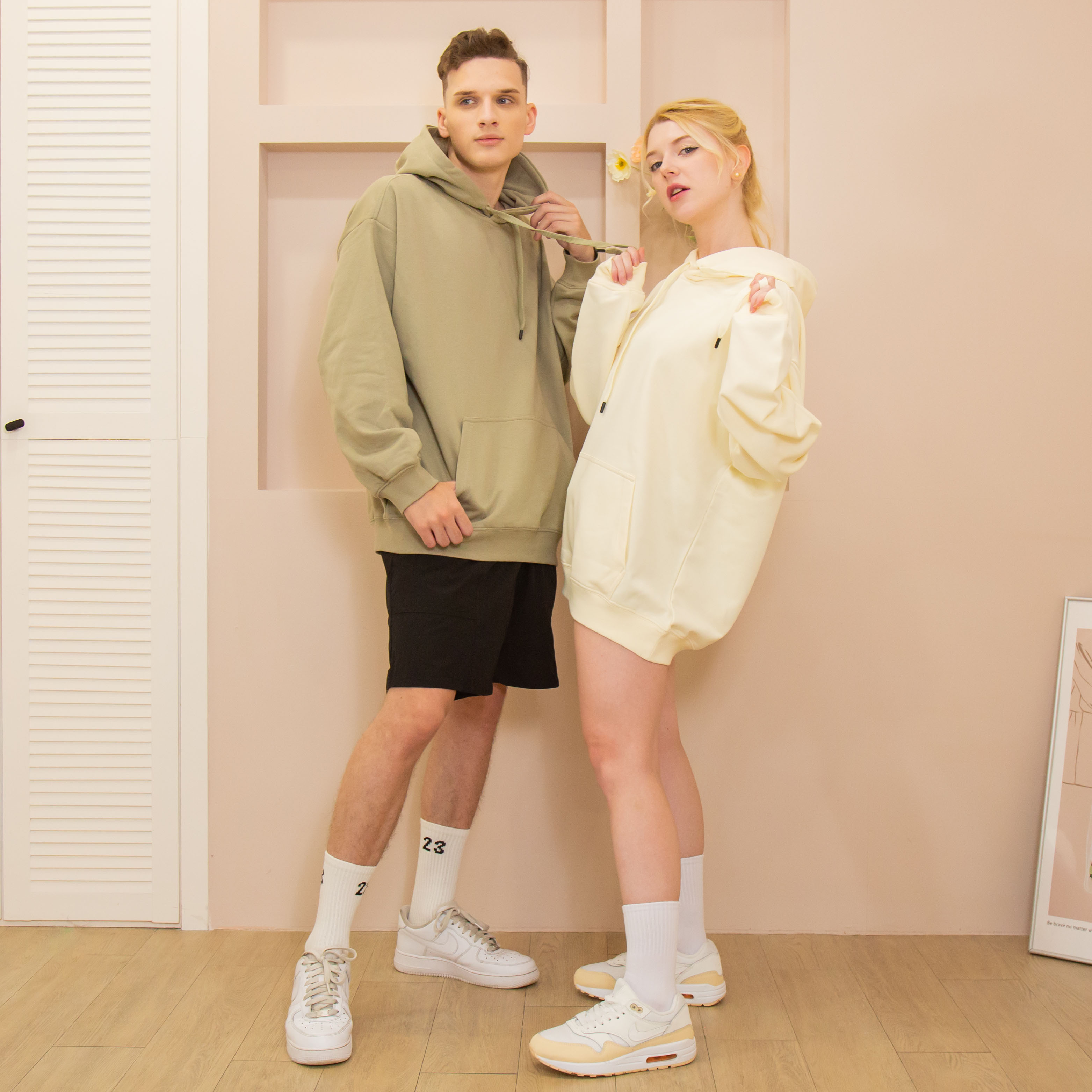 ArriveGuide 重磅寬版落肩帽T男模著苔蘚綠女模著奶油色