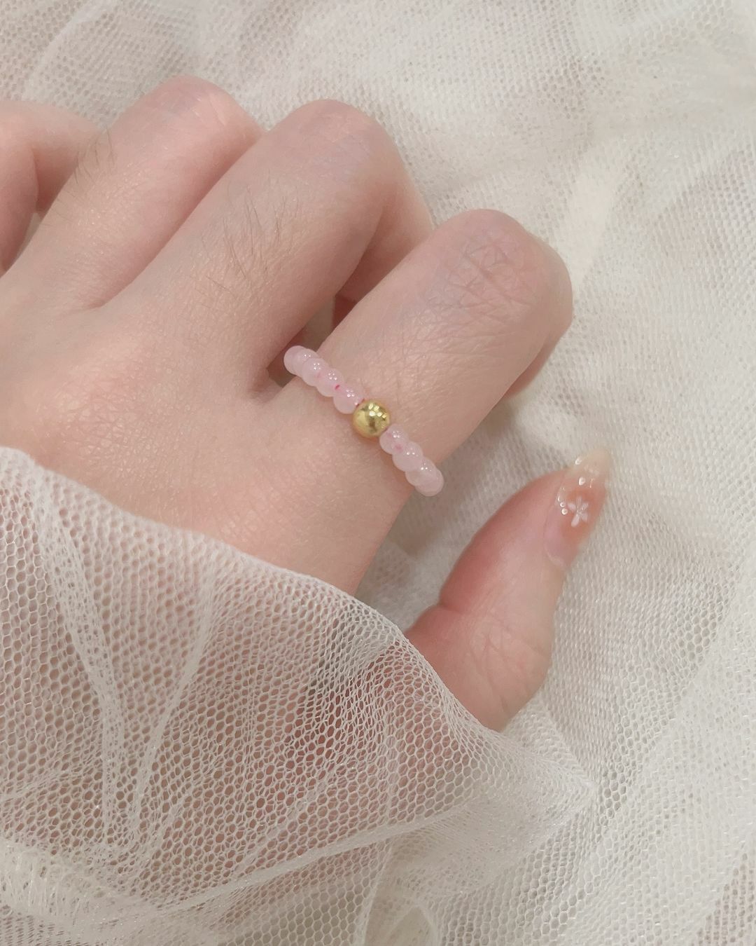 天然石戒指也可以很生活化🧸 這款粉晶彈力戒天天戴方便又可愛！  一顆顆粉晶串在一起像草莓甜甜圈🍓 如同粉晶被認為是讓人有好心情、討人喜歡、招好人緣的感覺💗 中間加了一顆金球 讓整體更亮眼 金屬+天然石真的是特別漂亮的結合✨  喜歡天然石但是覺得戒台戒指太正式的 或是常常需要碰水、做苦力的 非常推薦選擇這款唷(⁎⁍̴̛ᴗ⁍̴̛⁎)♡