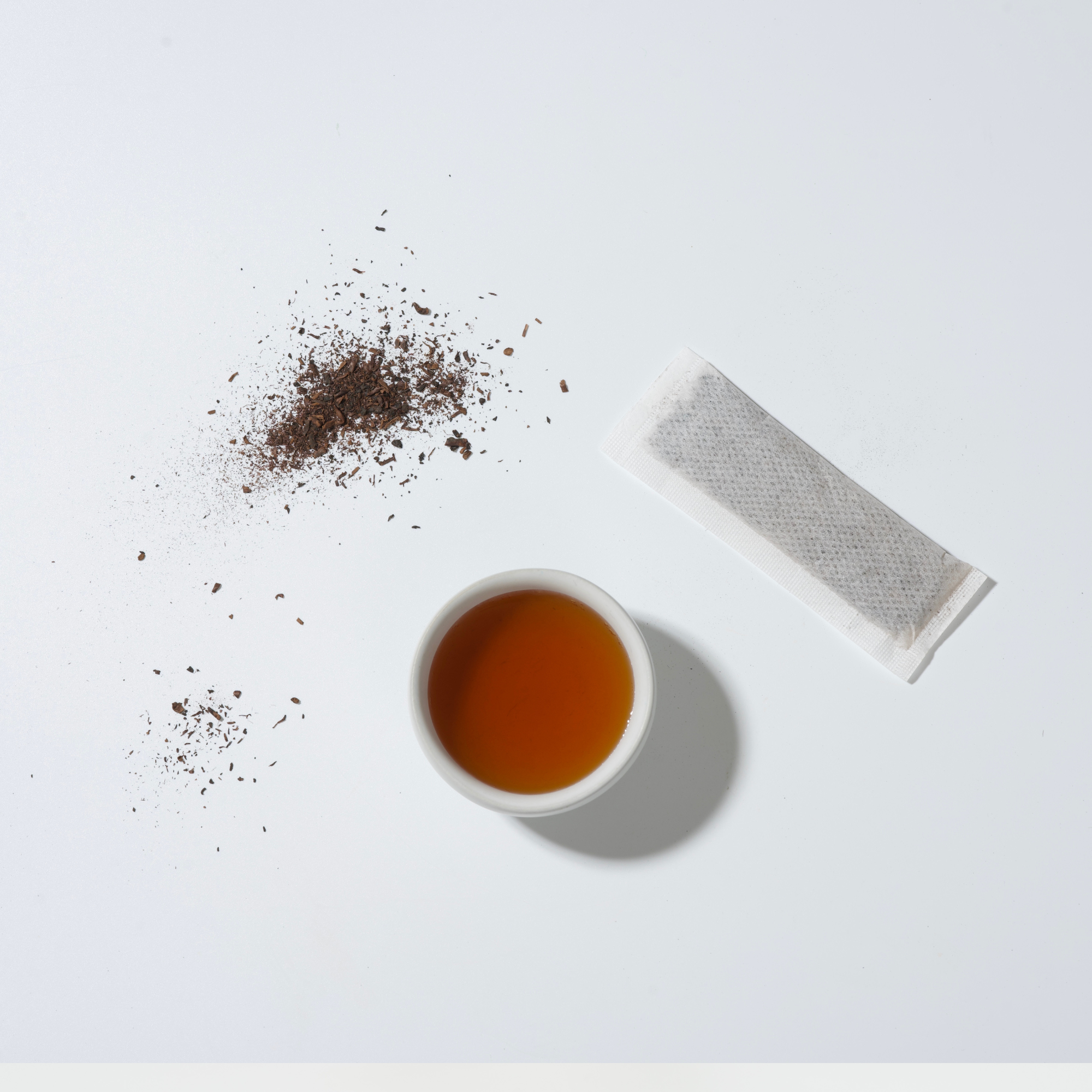 照片上有三毫克烏龍茶葉、茶包與深褐色茶湯