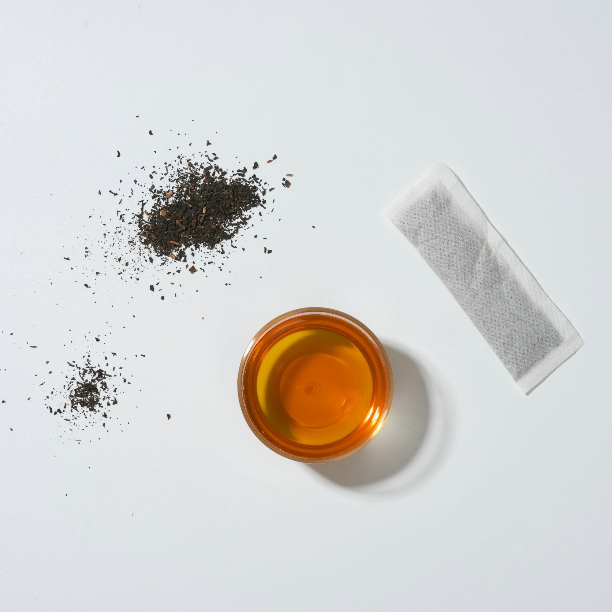 畫面裡,大小葉紅茶研磨冷萃茶葉、茶包與紅色茶湯