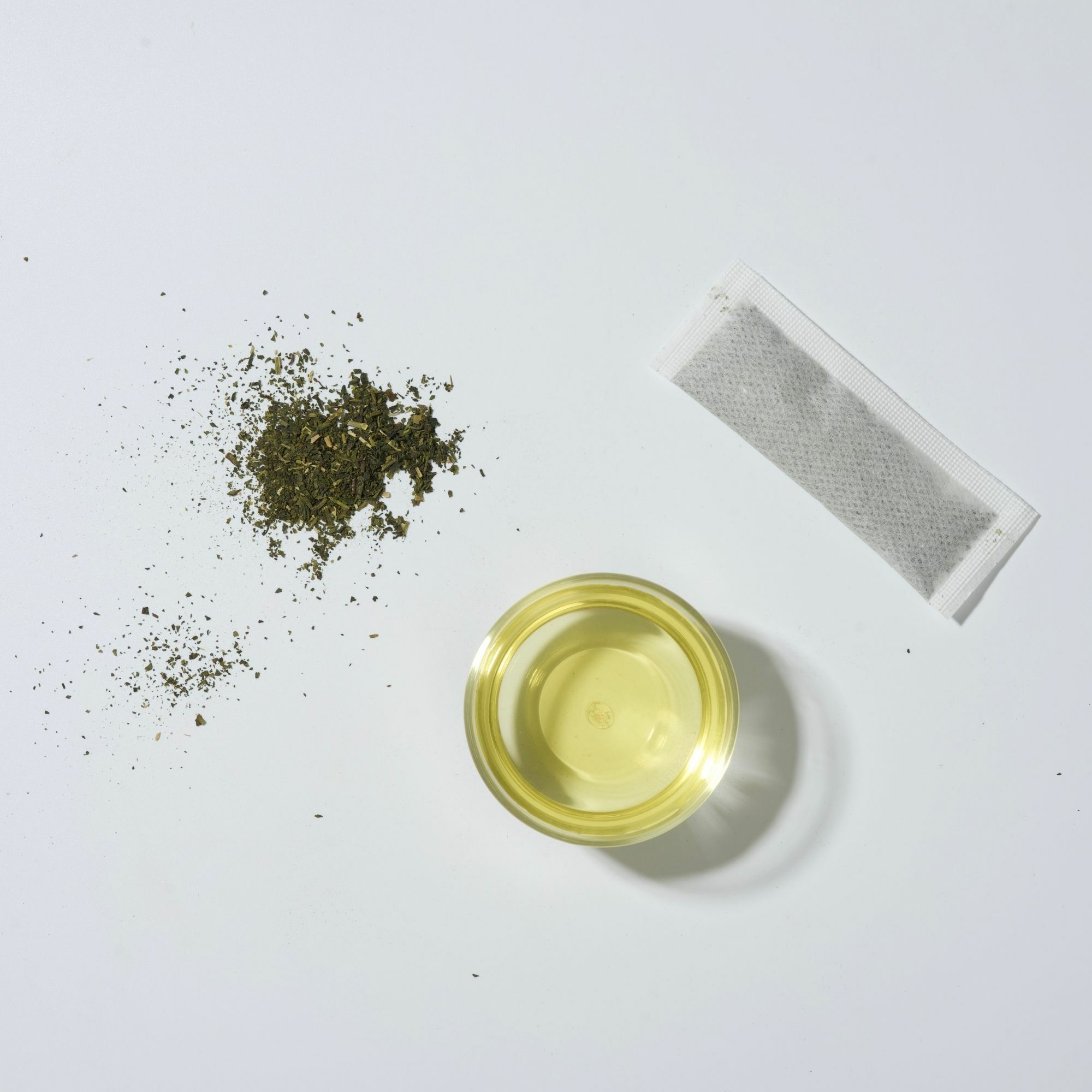 畫面裡,炒菁綠茶研磨冷萃茶葉、茶包與綠色茶湯