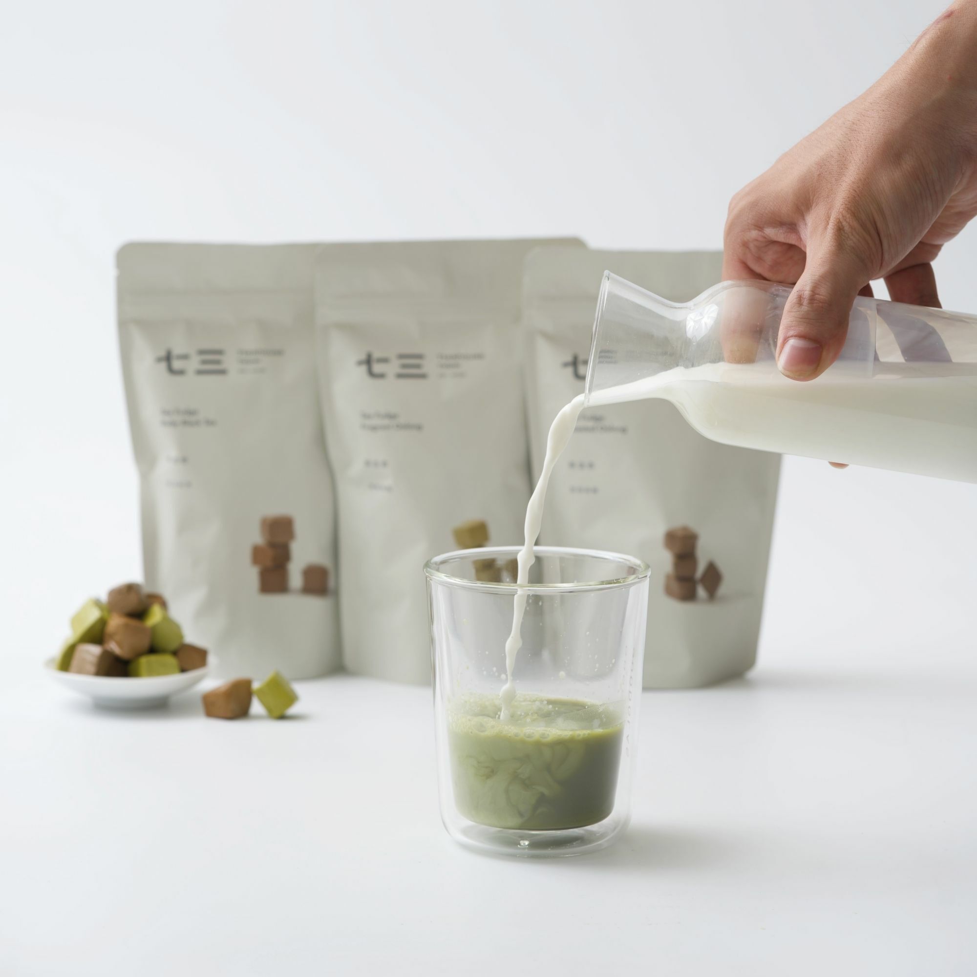 畫面裡有,茶法奇系列包裝與茶法奇,以鮮奶到入茶湯呈現漸層,表現嚼一顆糖彷彿喝了一杯鮮濃奶茶。