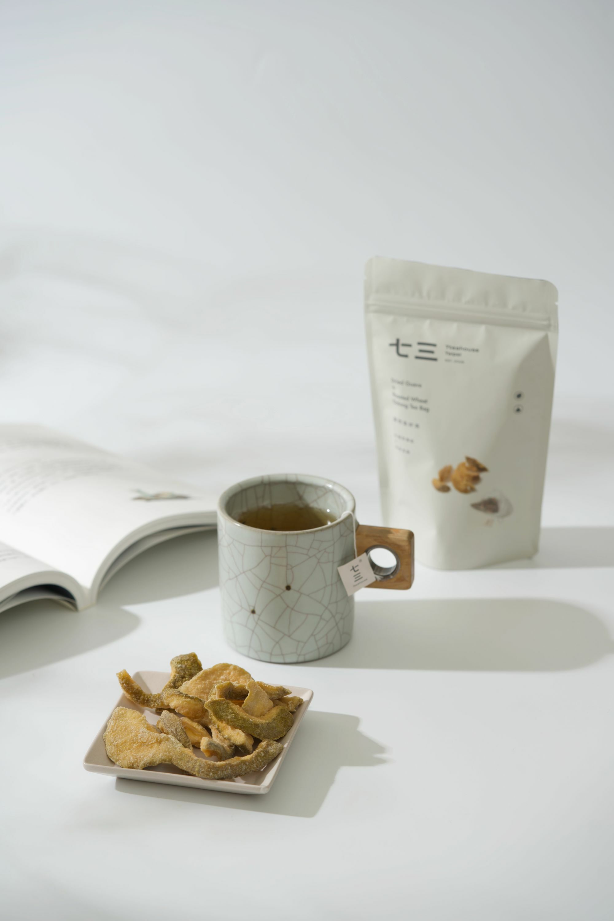 畫面裡，有書本搭配泡著麥香烏龍的馬克杯與芭樂乾和果然是好茶－社頭芭樂乾 ＆ 麥香烏龍商品呈現的午茶時光氛圍。
