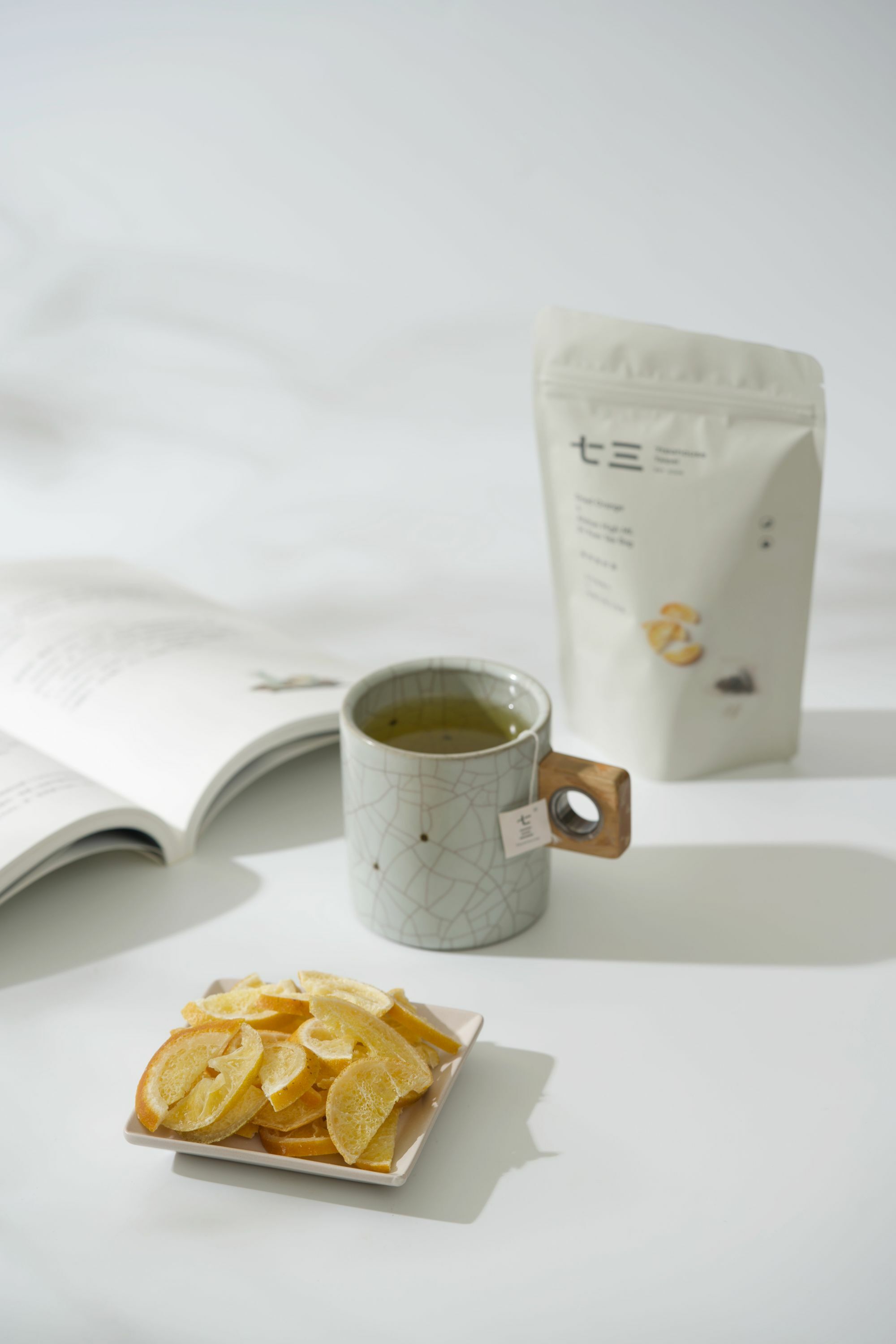 畫面裡，有書本搭配泡著麥香烏龍的馬克杯與芭樂乾和果然是好茶－古坑柳橙片 ＆ 阿里山高山金萱商品呈現的午茶時光氛圍。