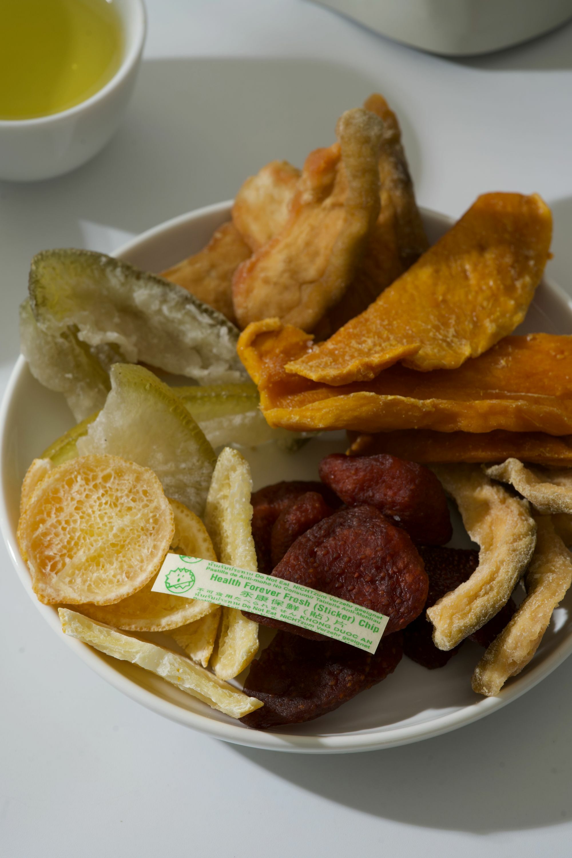 細菌不喜歡「哇沙米 Wasabi 山葵」的味道,因此,每一果乾包裝內都有塗上些許「哇沙米」的紙條。以天然的方式保存果乾,但不影響風味。畫面裡有台灣豐富的果乾與一只「哇沙米」的紙條。