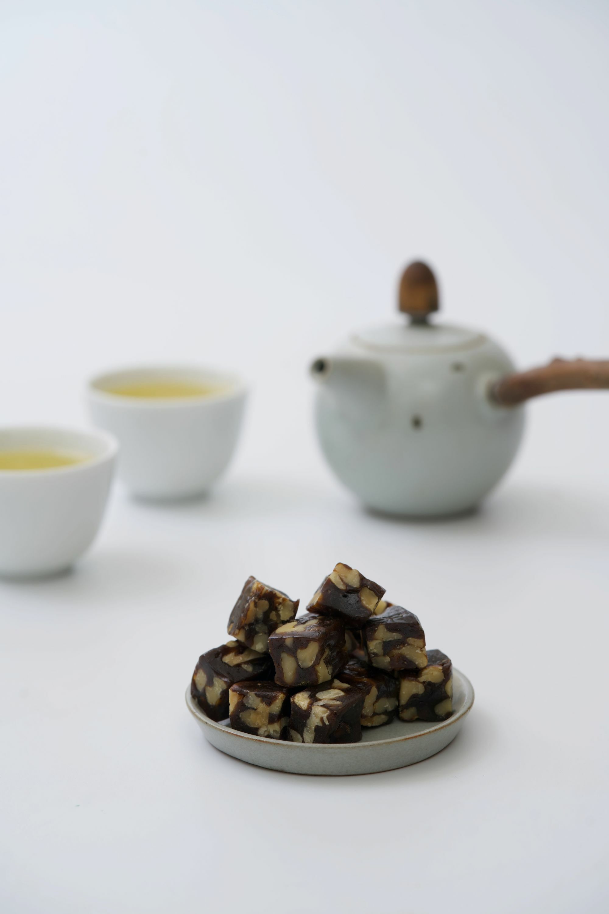 畫面裡,聚焦在蜜香核棗糕本身,虛化背景茶杯、茶湯與茶壺。