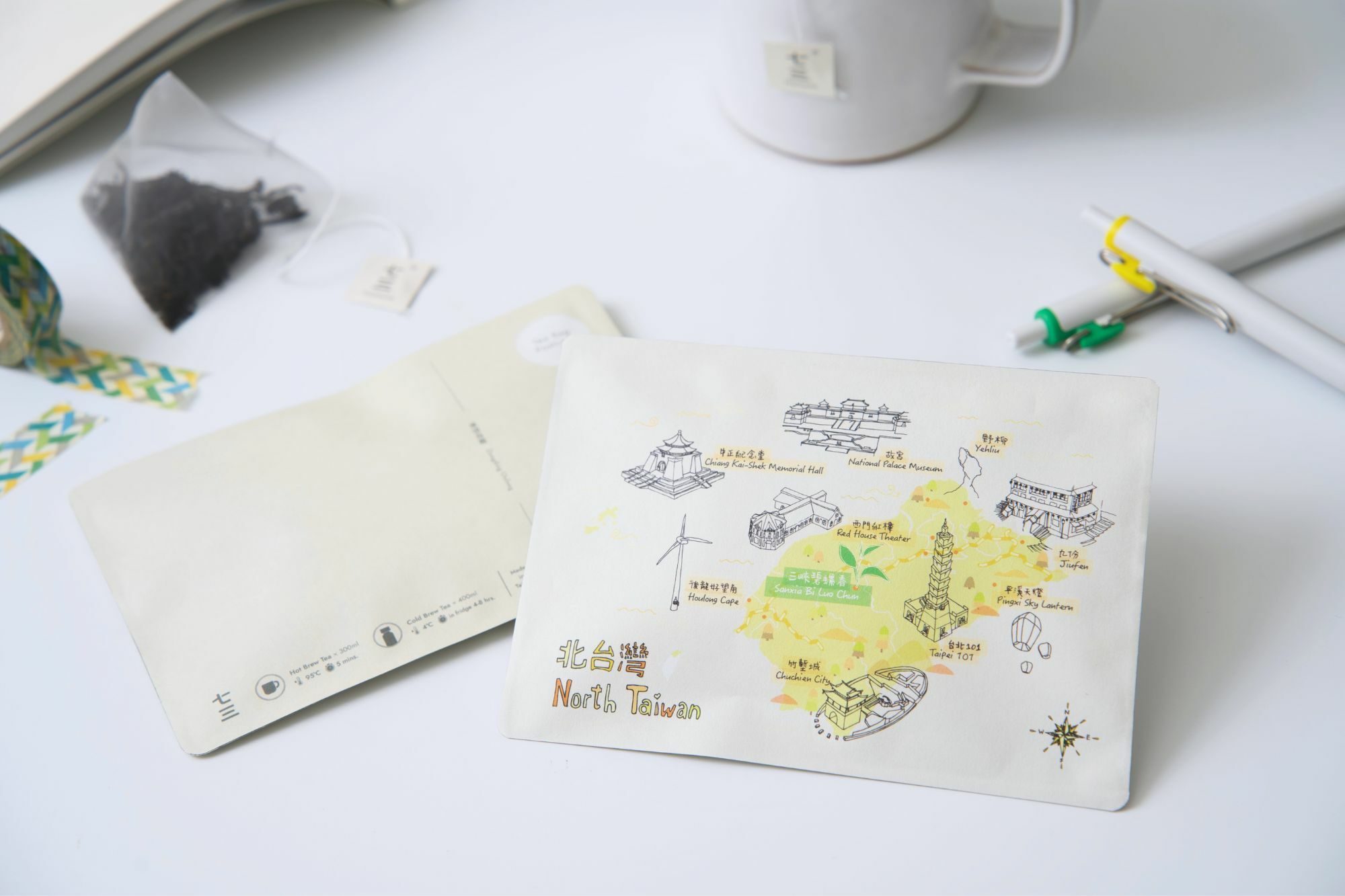 畫面裡,有茶包明信片-旅台款-北台灣,與書本、筆、紙膠帶、泡著三峽碧螺春茶包的馬克杯,呈現的情境氛圍。