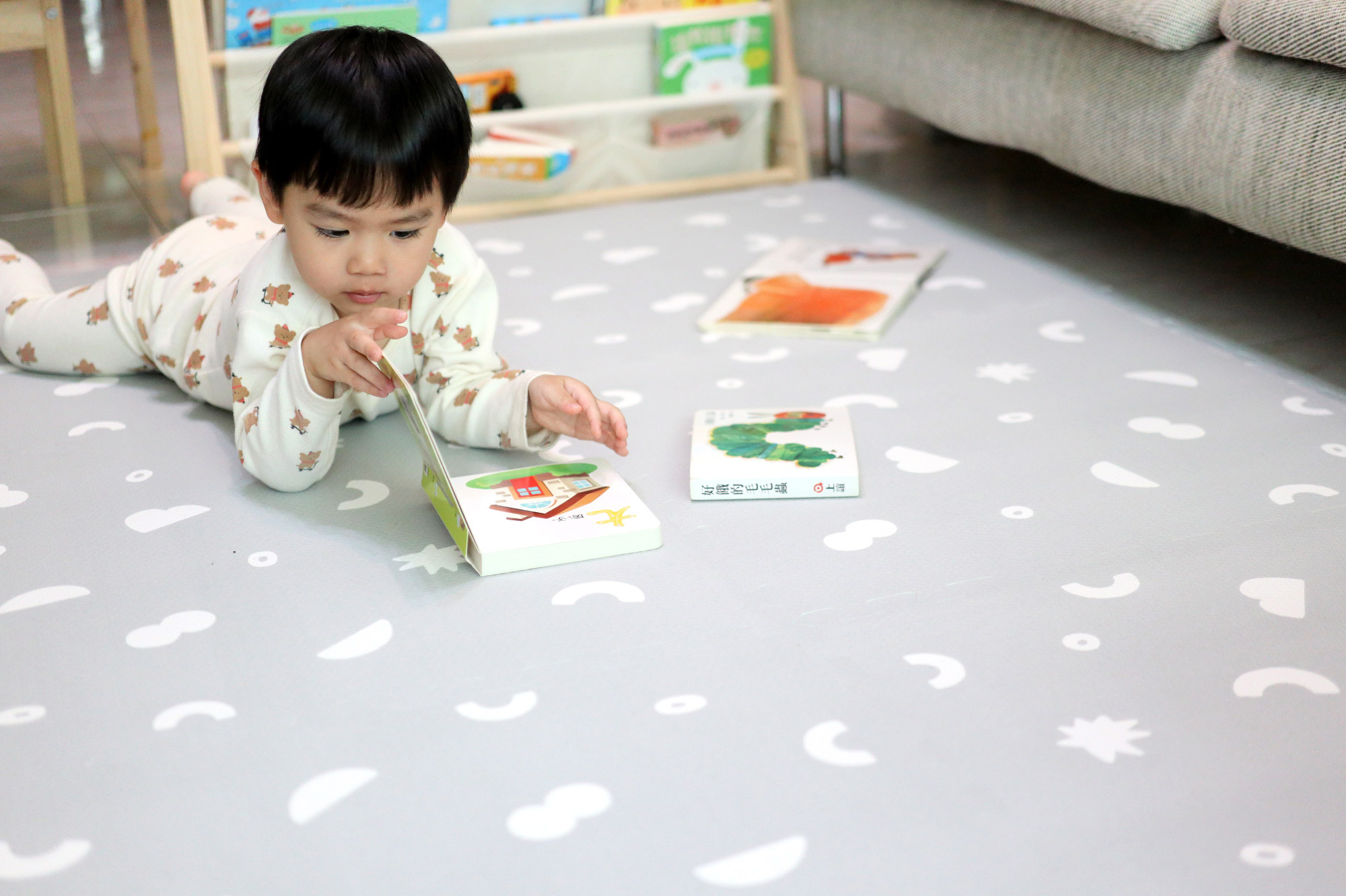這是一張小孩在地墊上看書的照片